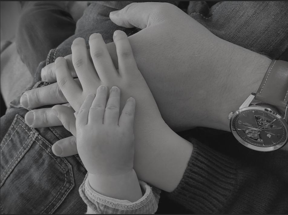 Le lien de la famille avec les mains posées les unes sur les autres. La montre fait écho au fait de créer des souvenirs intemporels