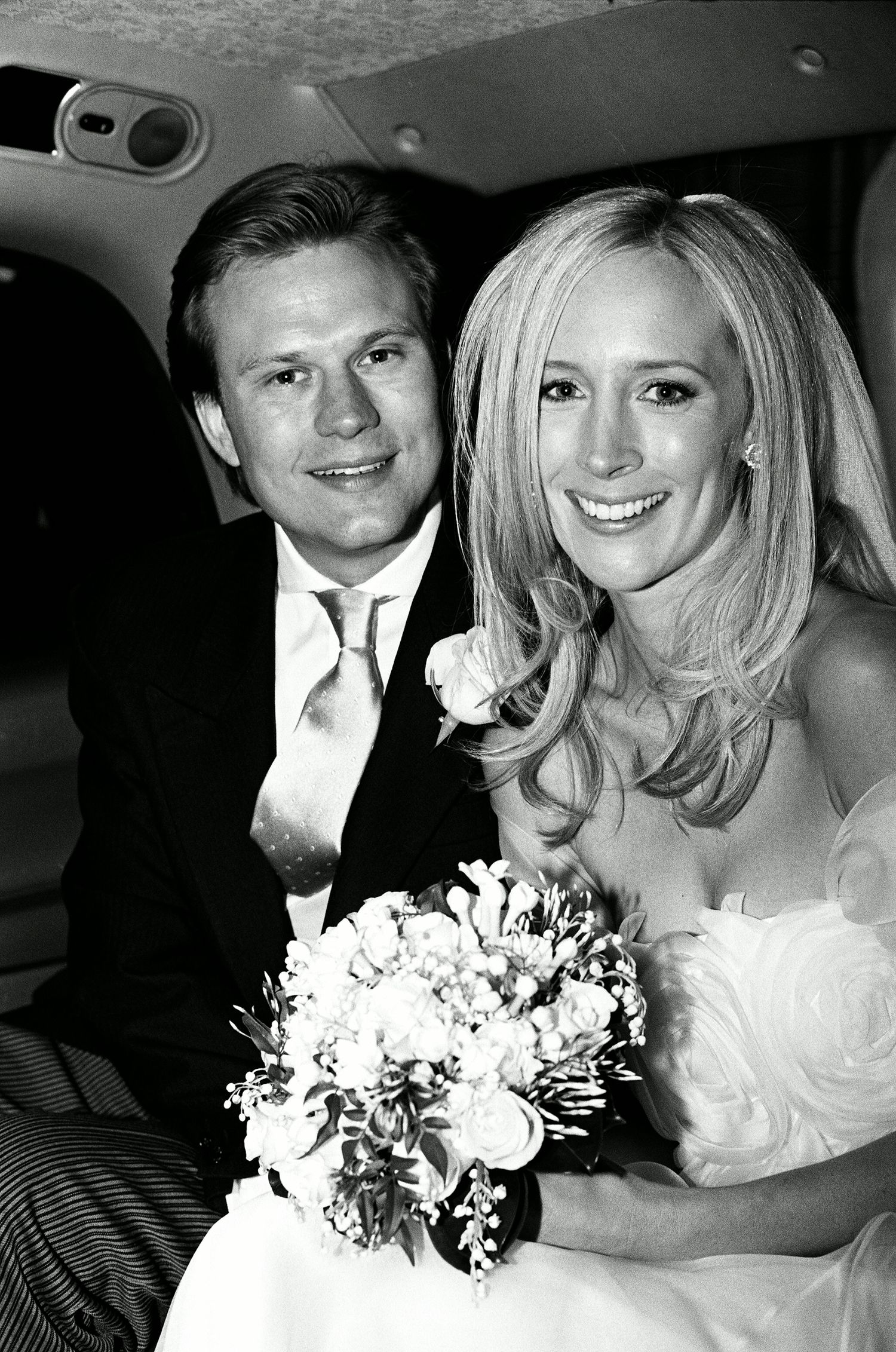 Black and white wedding portrait showing newlyweds with bridal bouquet.
