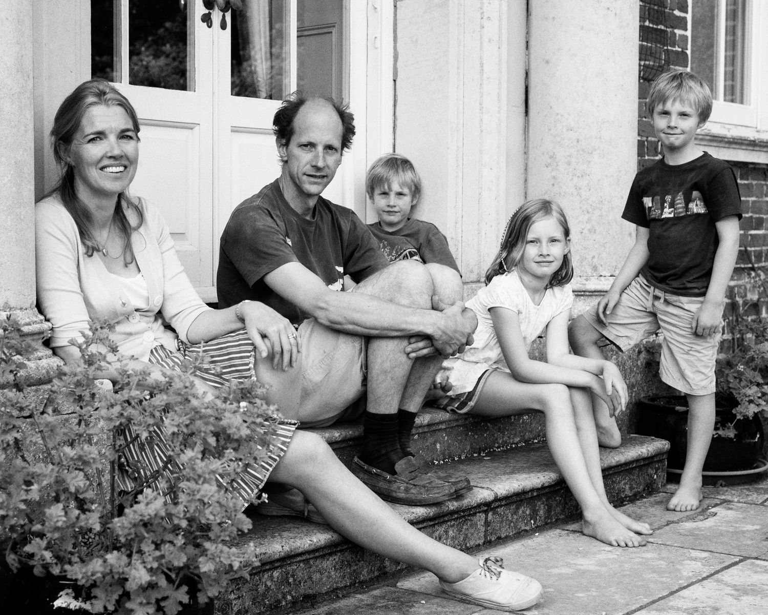 Casual family portraits taken on a front porch step in black and white.