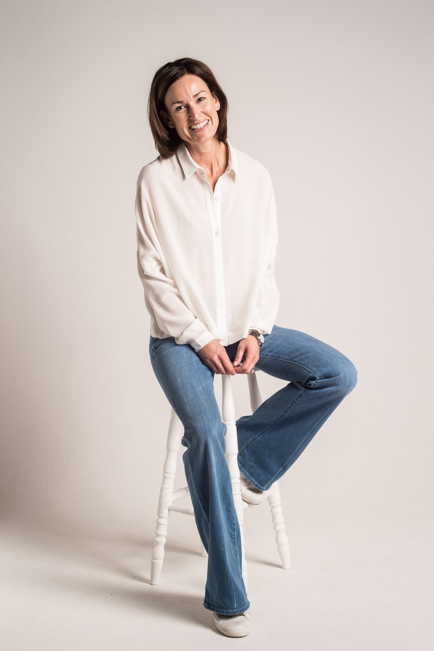 Fashion series showing casual white shirt and jeans outfit on white background.