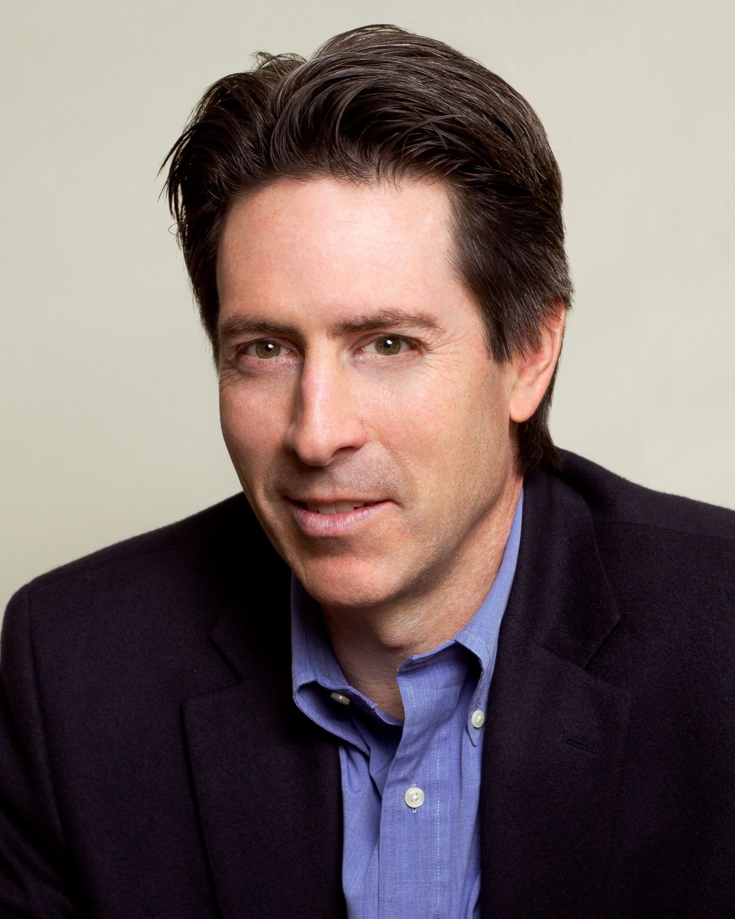 Professional headshot series of Scott Malkin in navy blazer and blue shirt with varying expressions.