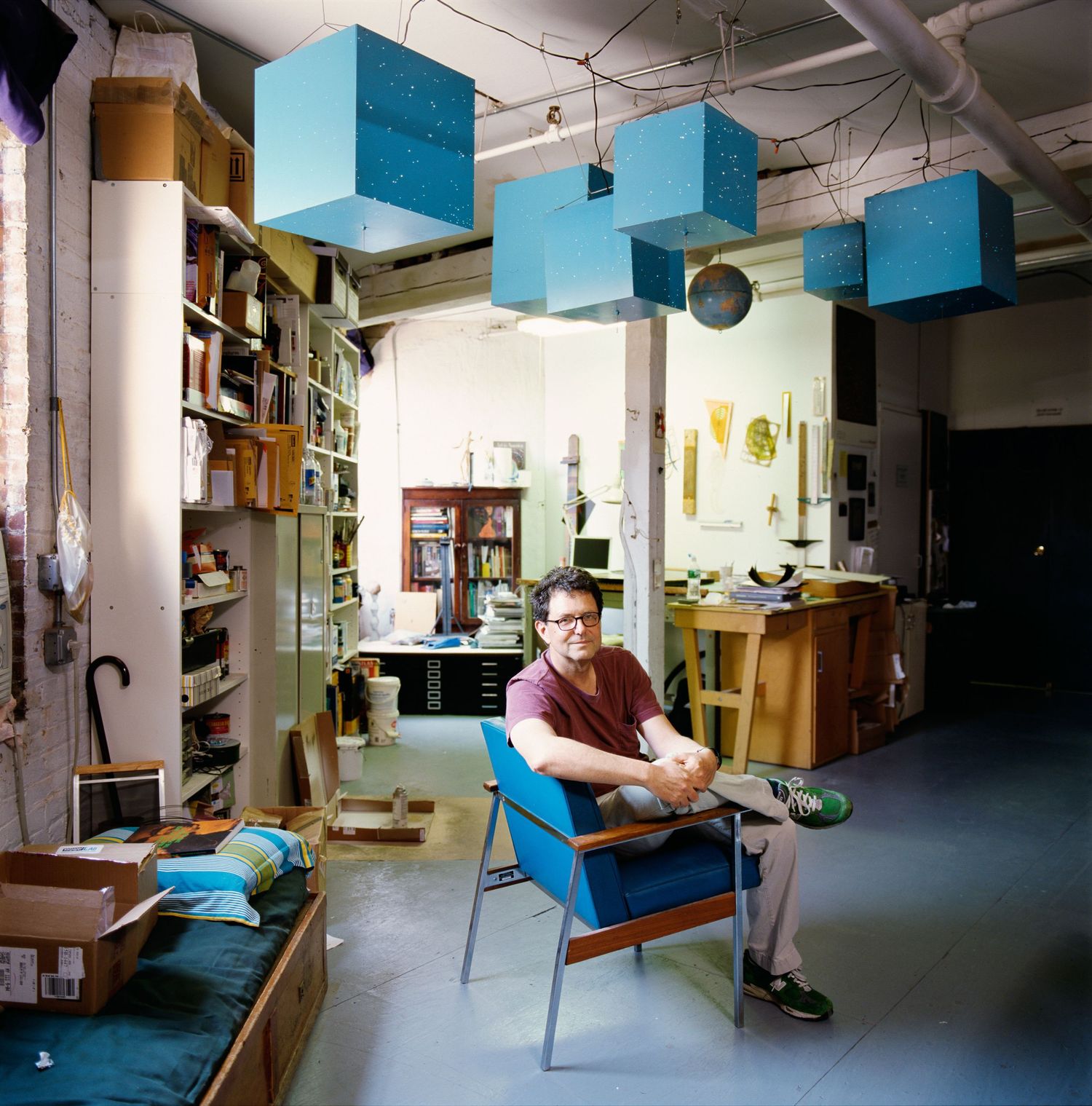 Empty studio space with blue walls and scattered furniture.