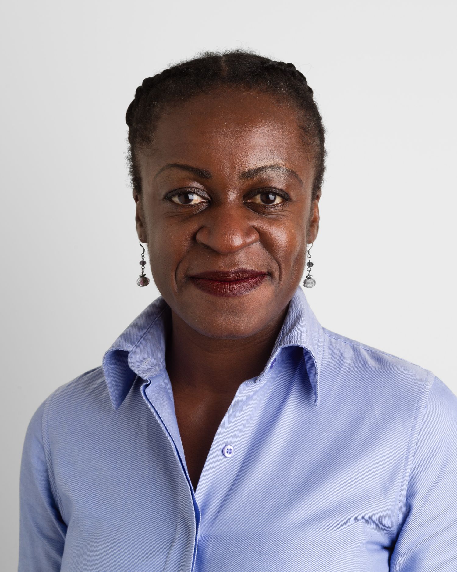 Business headshot Portrait of a person wearing light blue collared shirt and silver earrings.