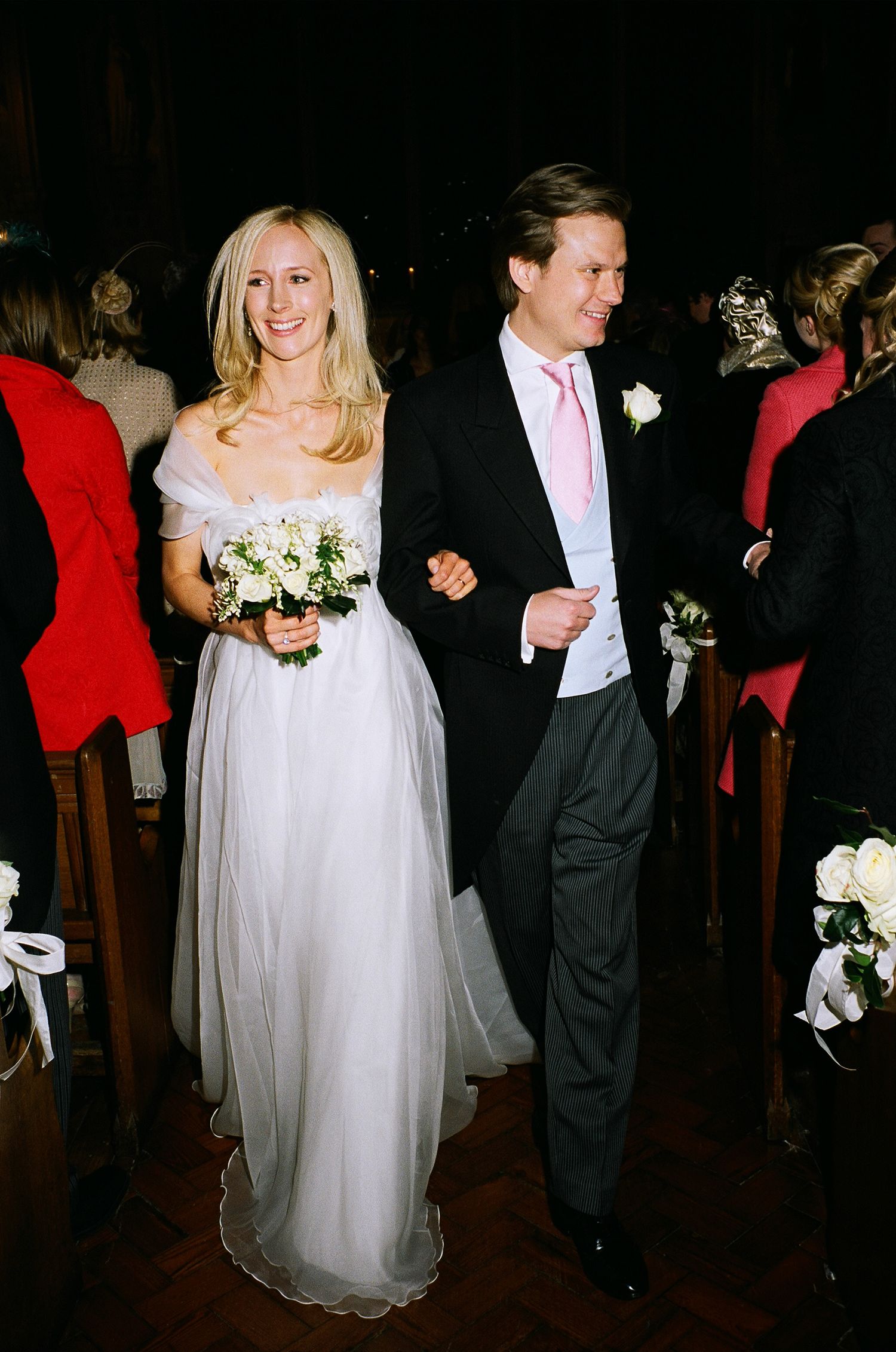 Wedding couple walking together during evening reception celebration.