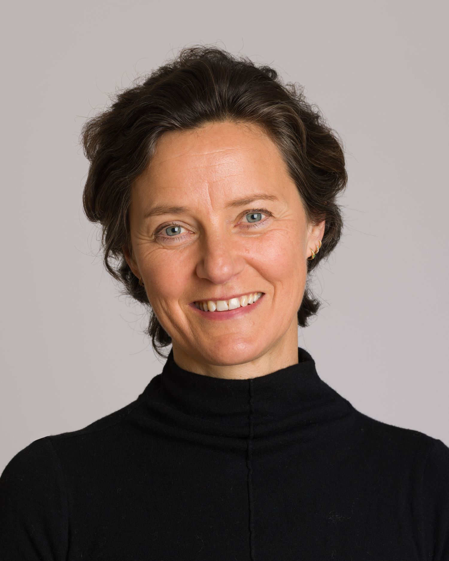 Professional Business headshot portrait sequence showing someone in black turtleneck against grey background.