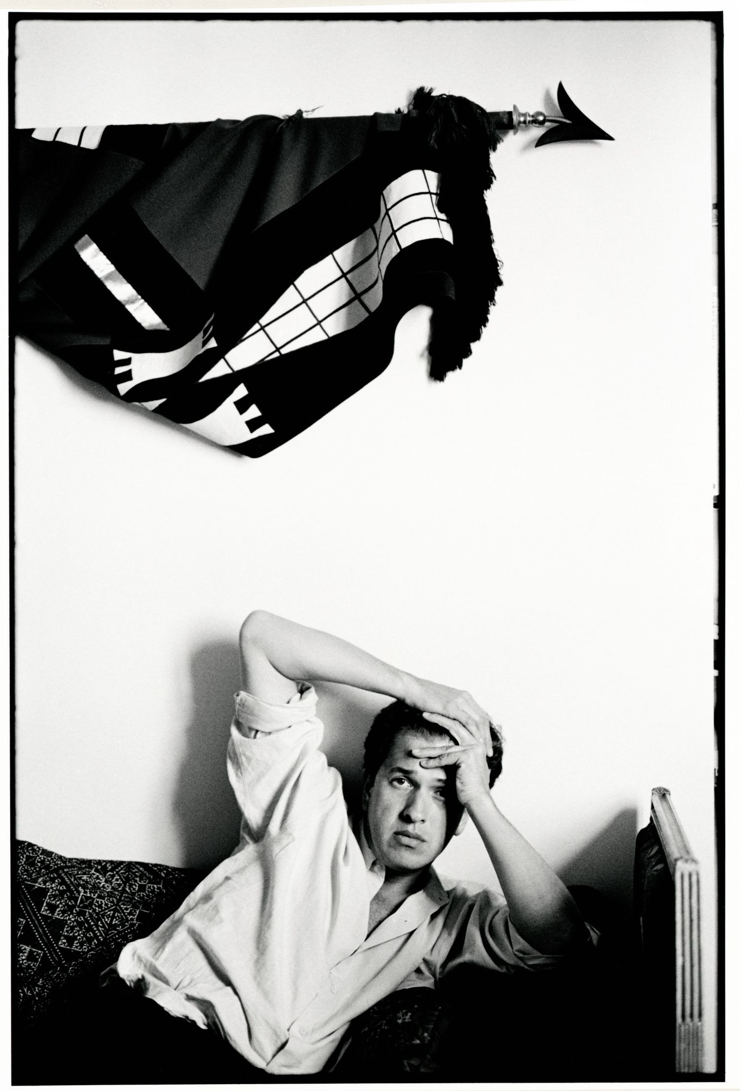Black and white artistic portrait series of Mario Testino showing dramatic poses against a white background.