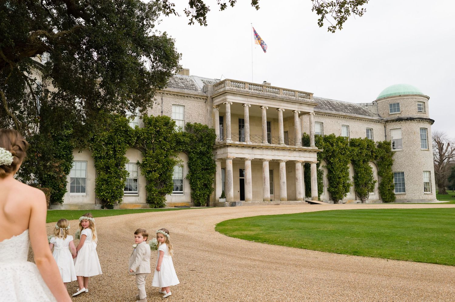 Elegant historic mansion with white columns and curved driveway serves as wedding venue.