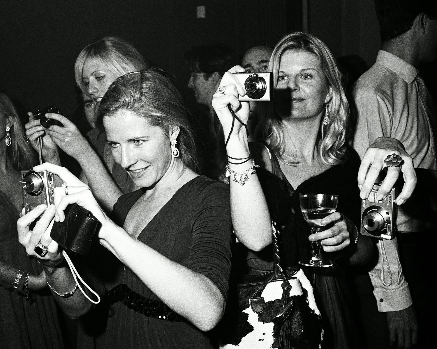 group of young white British ladies at a party photographing with point and shoot digital and film cameras