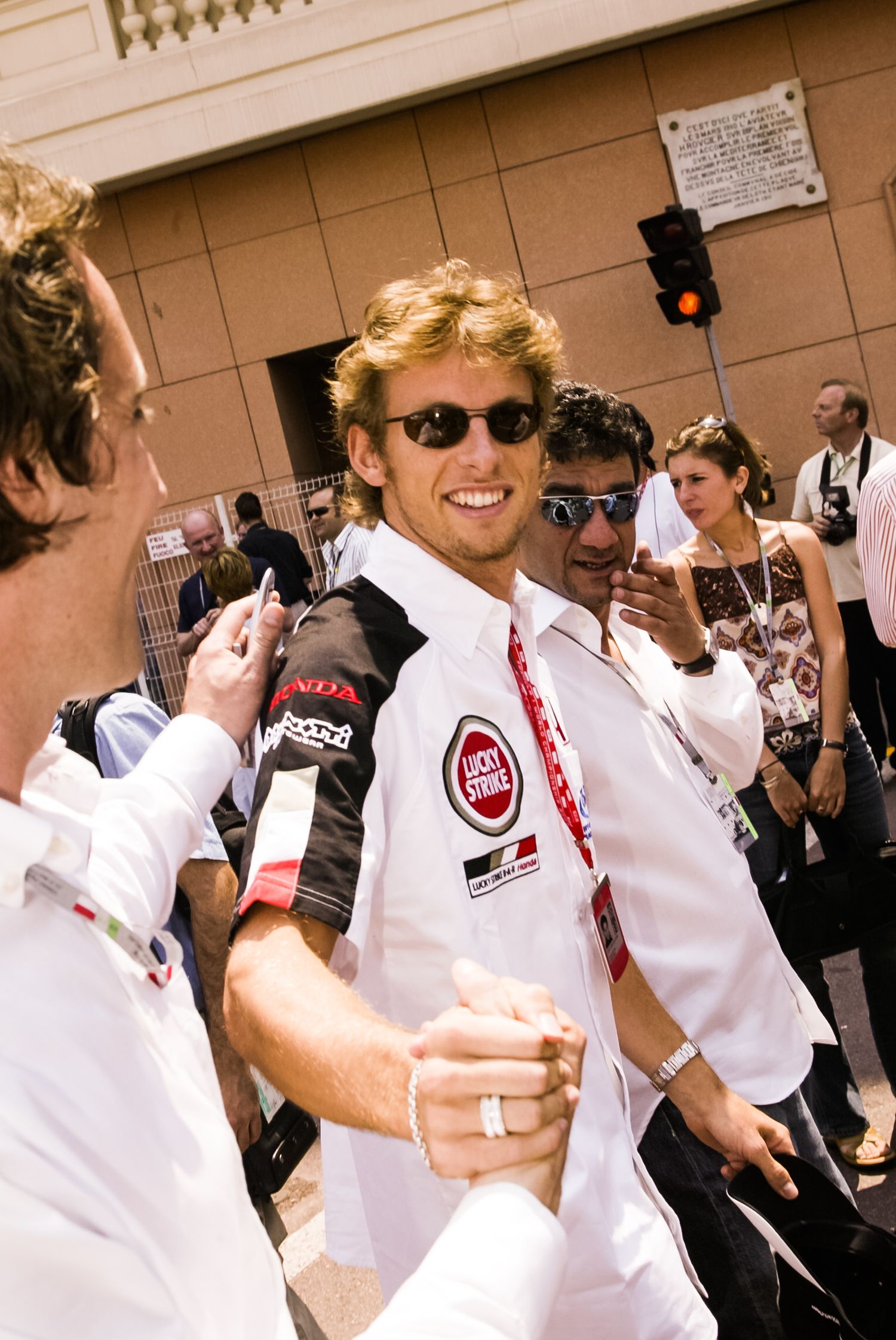F1 driver and Racing team members in white uniforms gather at motorsport event Monaco Grand Prix