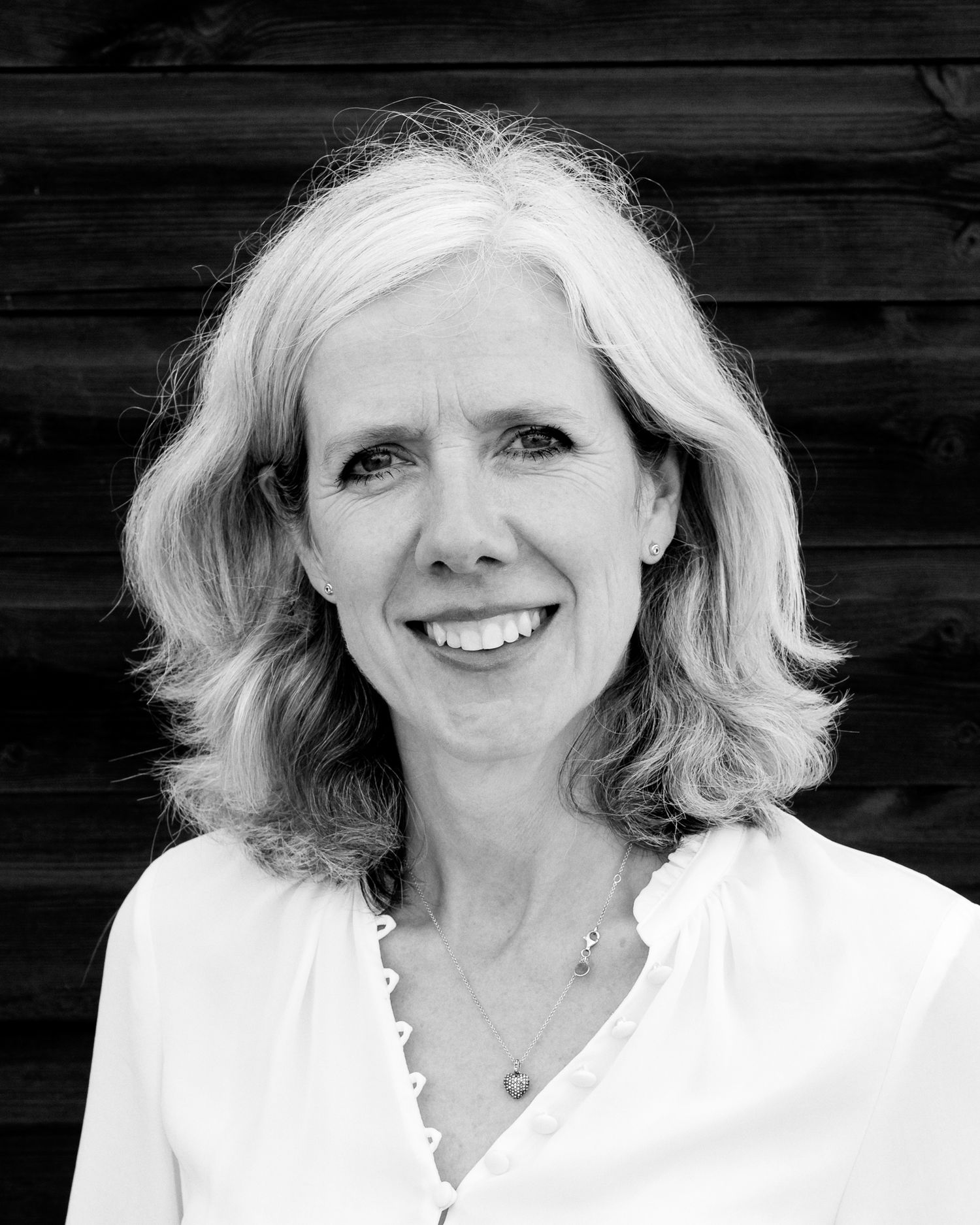 Black and white headshot series of someone in white clothing against dark background.