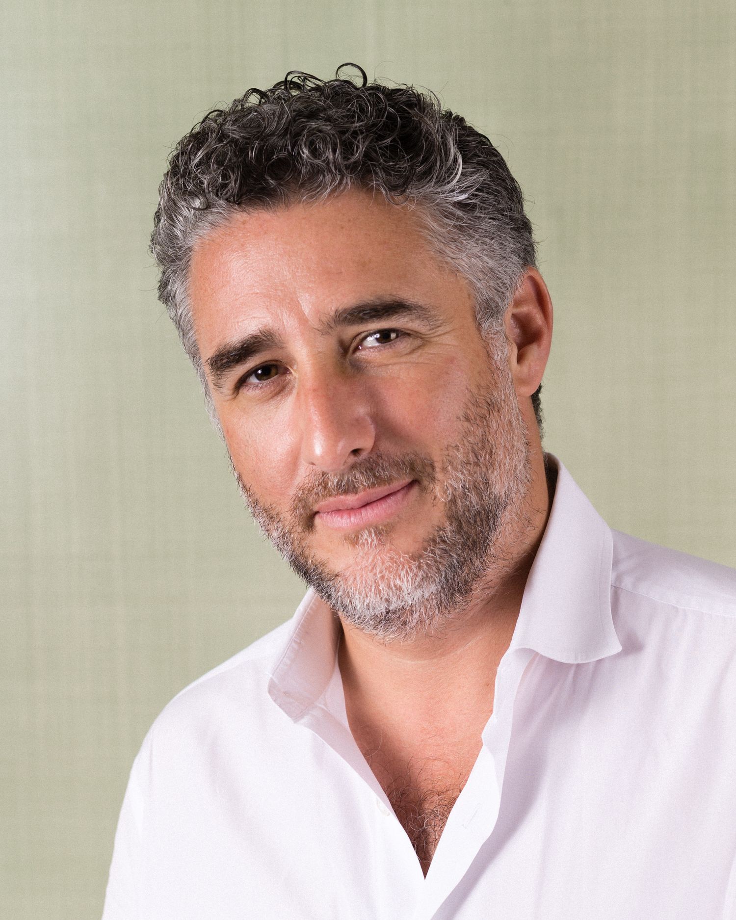 Professional portrait series of Luca Dell Bono in white shirt with salt and pepper beard against light background.