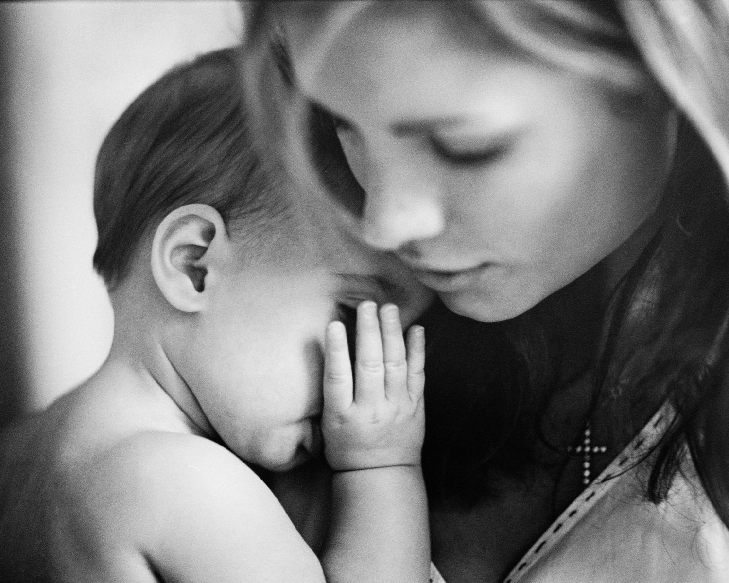 Intimate black and white close-up photograph showing tender moment.