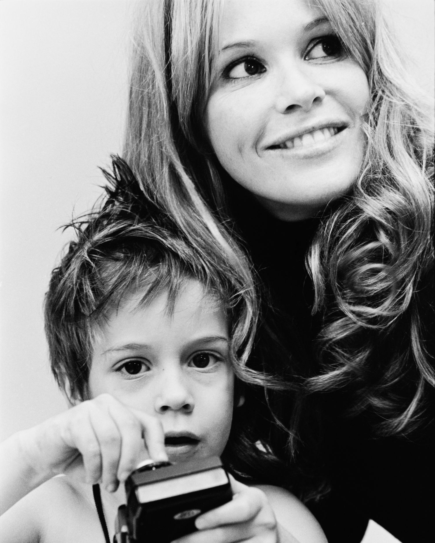 Close-up black and white portraits of Elle Macpherson showing playful expressions and interactions.