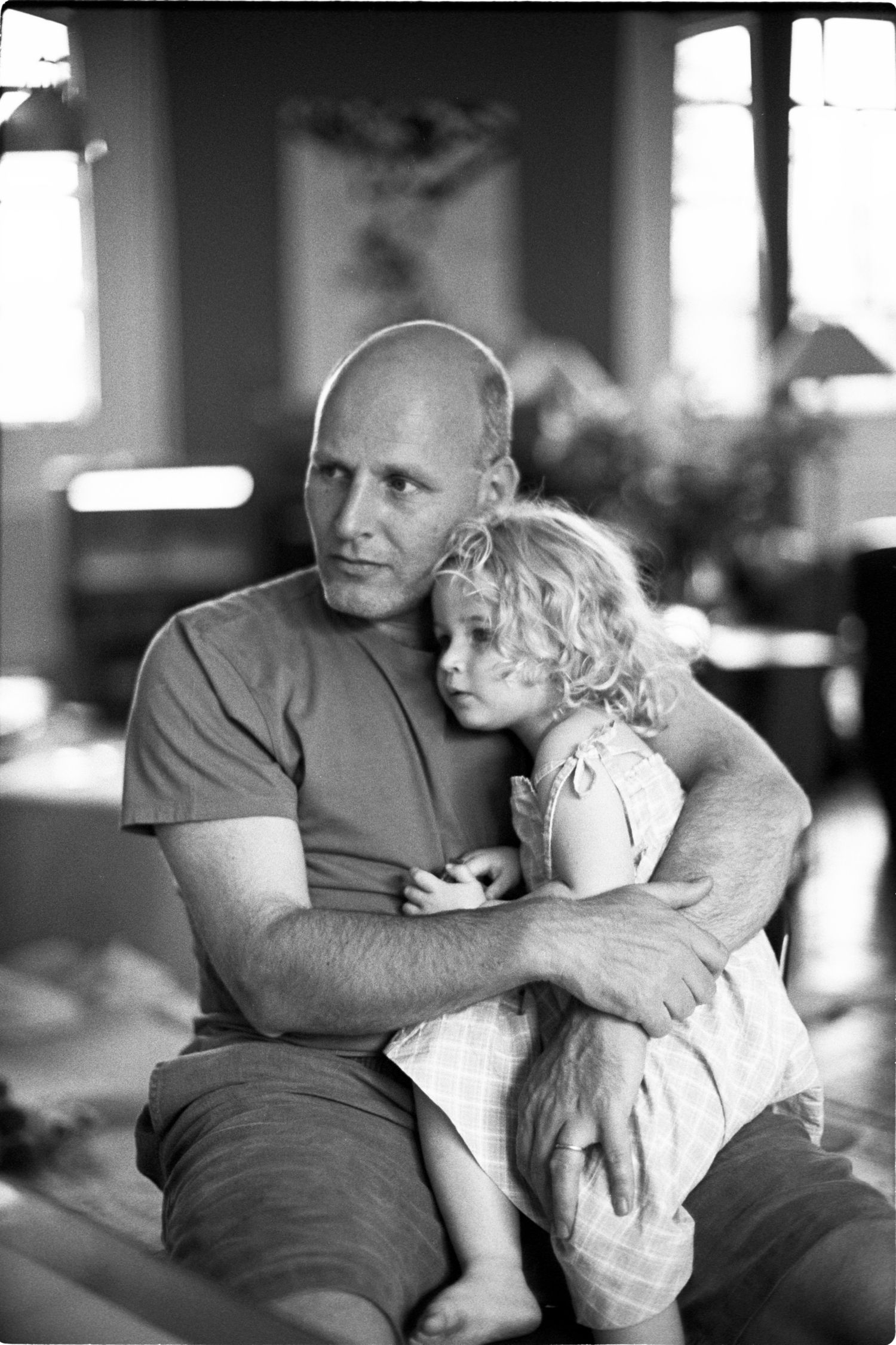 Black and white portrait showing tender moment between parent and child.