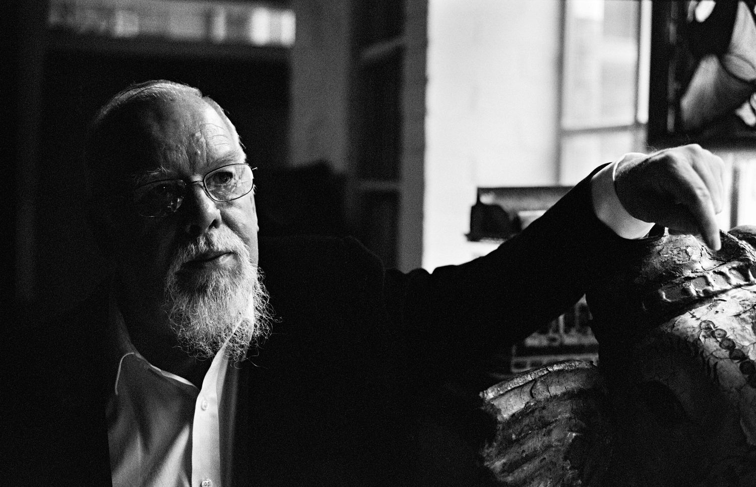 Series of moody black and white portraits of artist Peter Blake with dramatic side lighting.