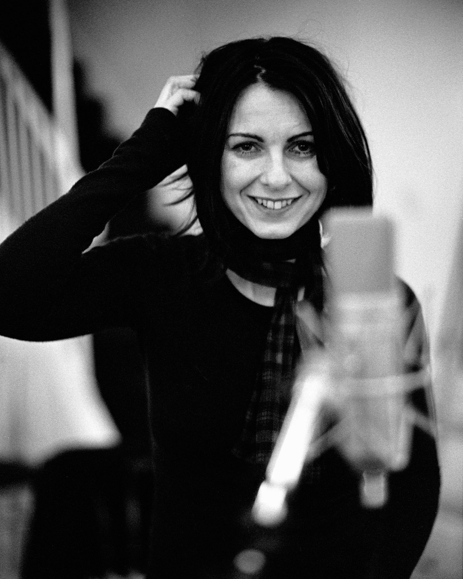Black and white portrait series showing playful expressions and dark hair against light background. Singer at microphone in recording studio