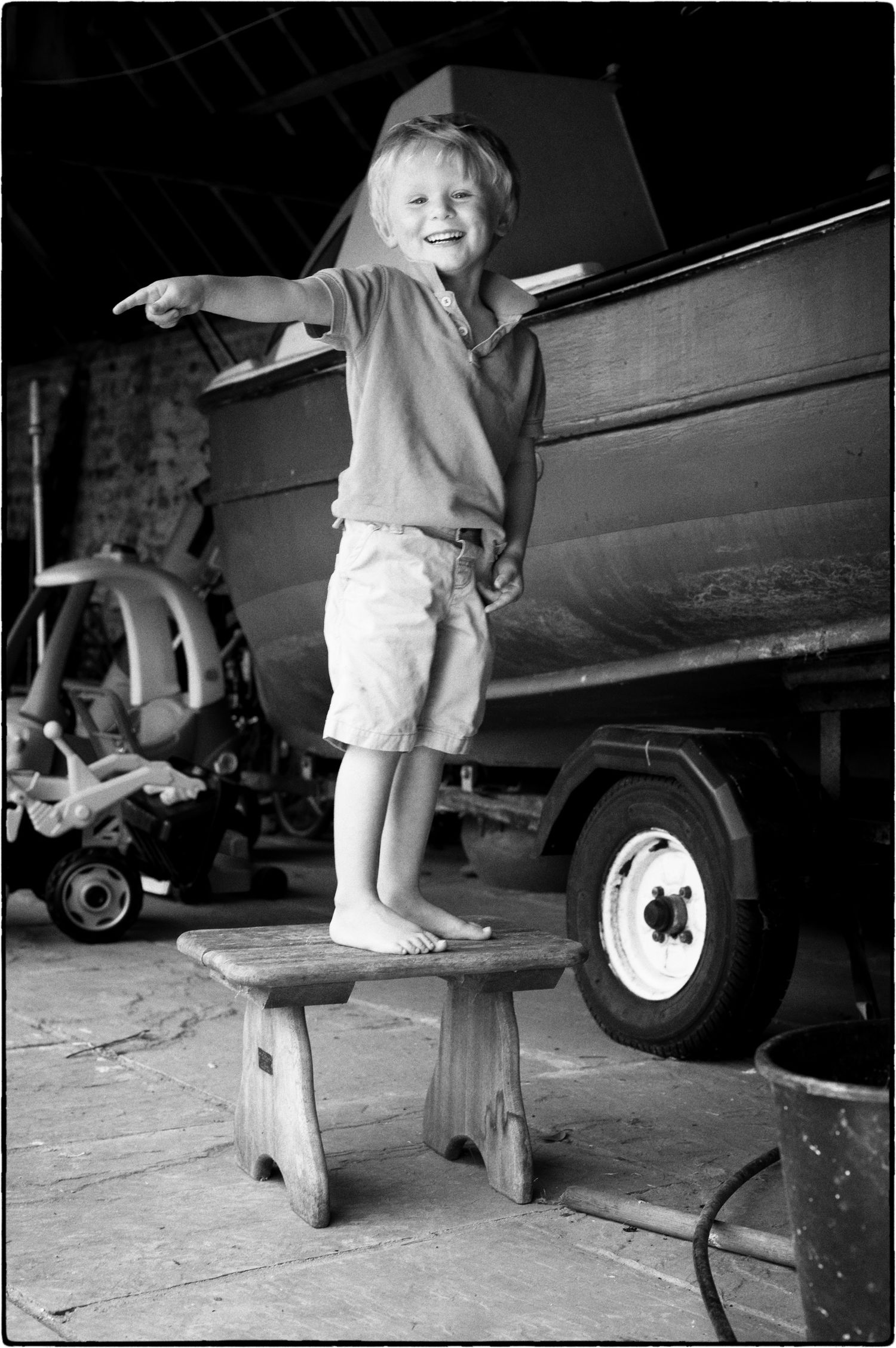 Black and white sequence showing small feet walking on wooden planks near vehicle wheels.