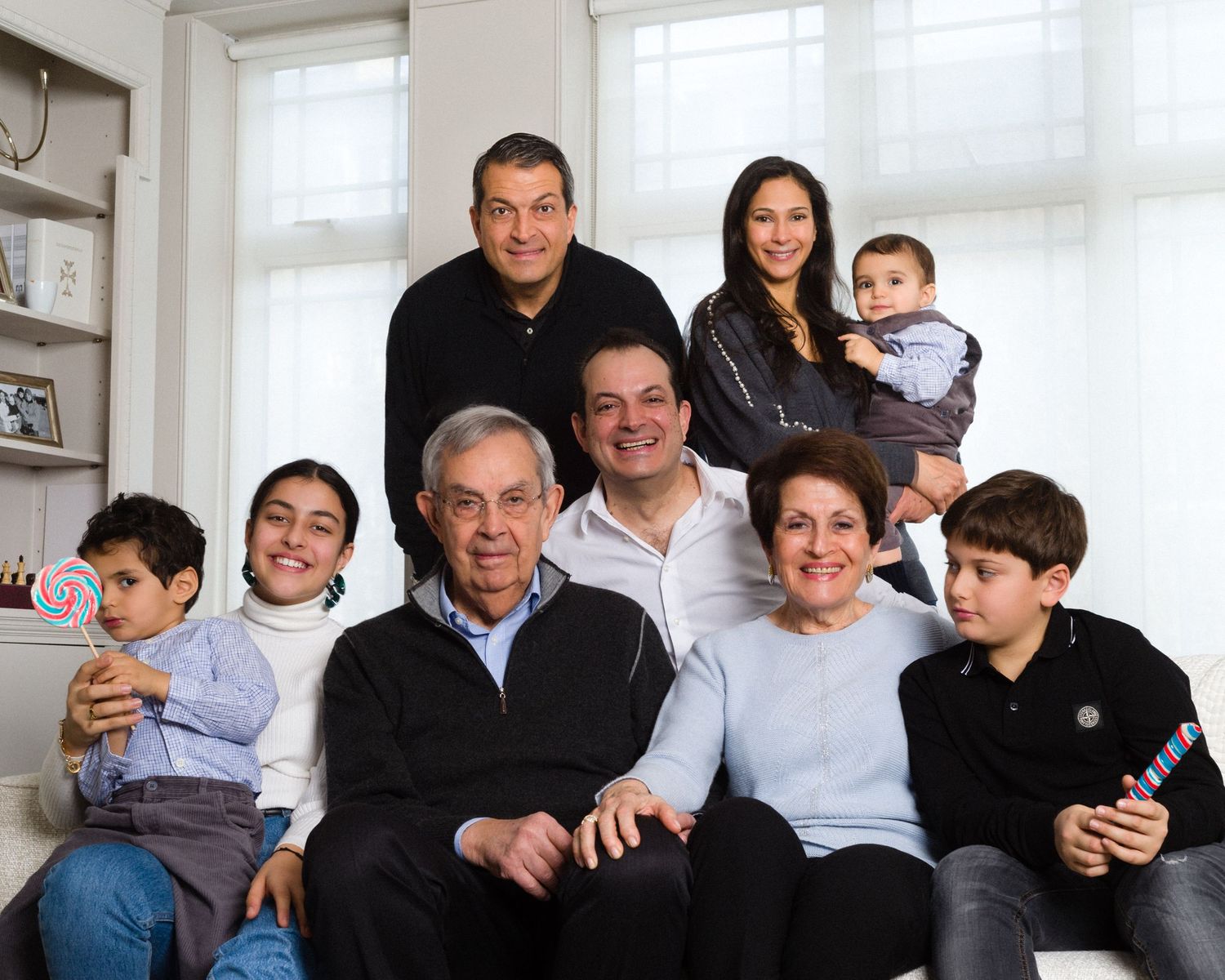 Multi-generational family gathered on couch for indoor portrait session central London