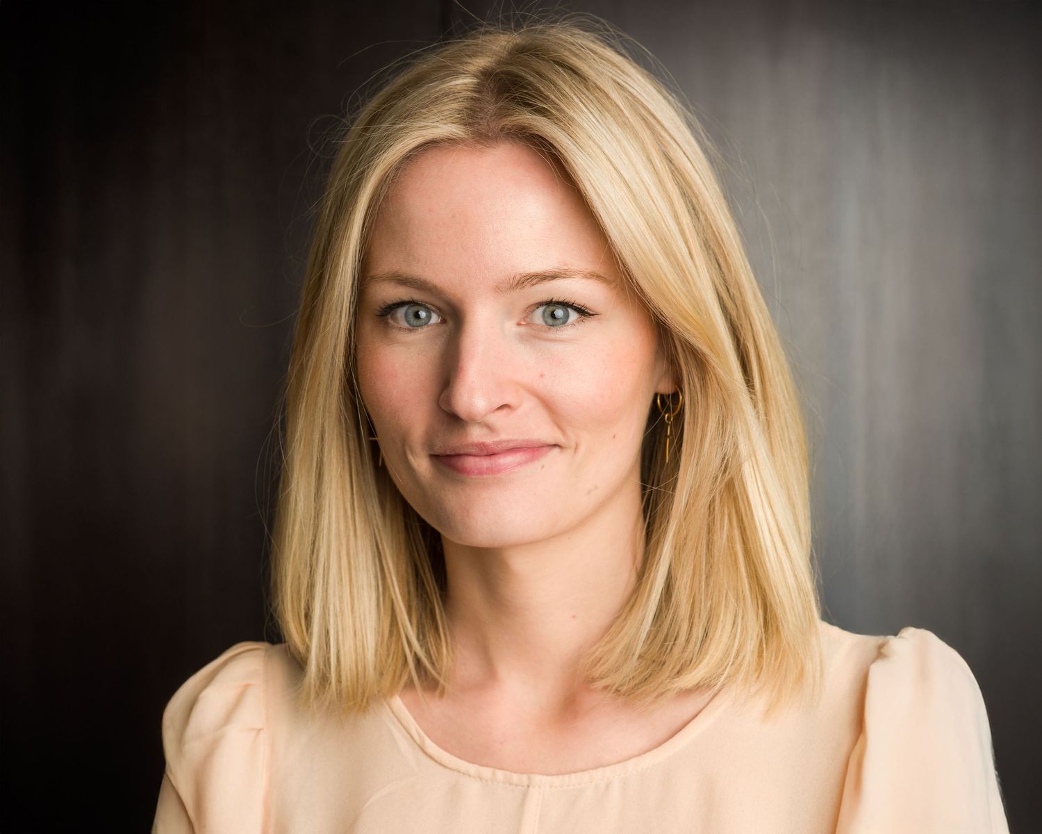 Professional headshot series showing different expressions against dark background.