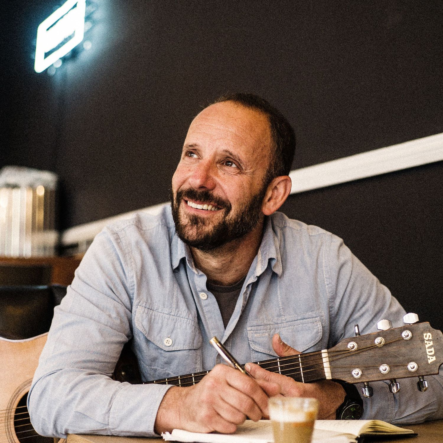 Series of casual portraits at a bar with guitar and drinks.