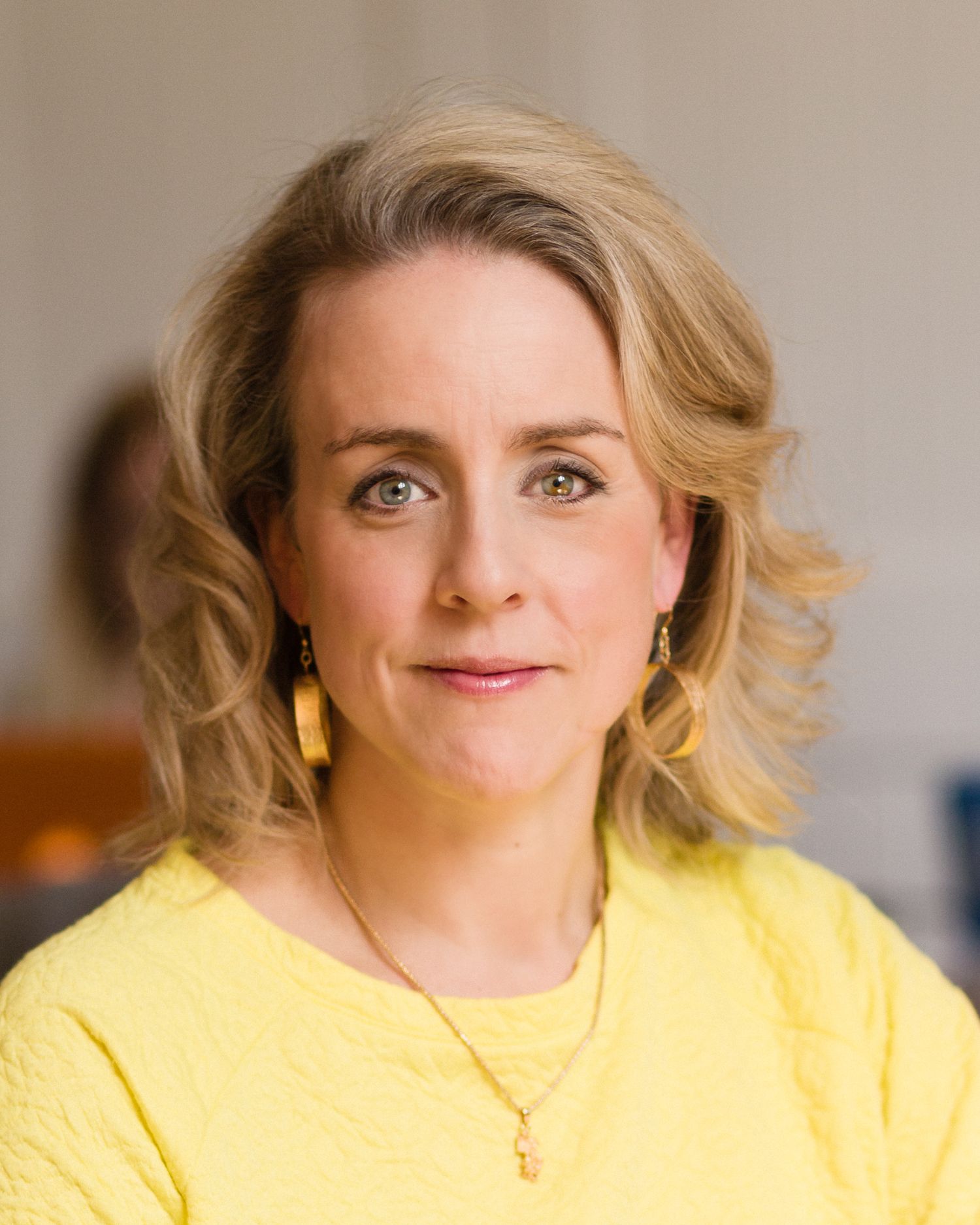 Portrait series showing artist Nicola Green in yellow top with blonde hair against neutral background.