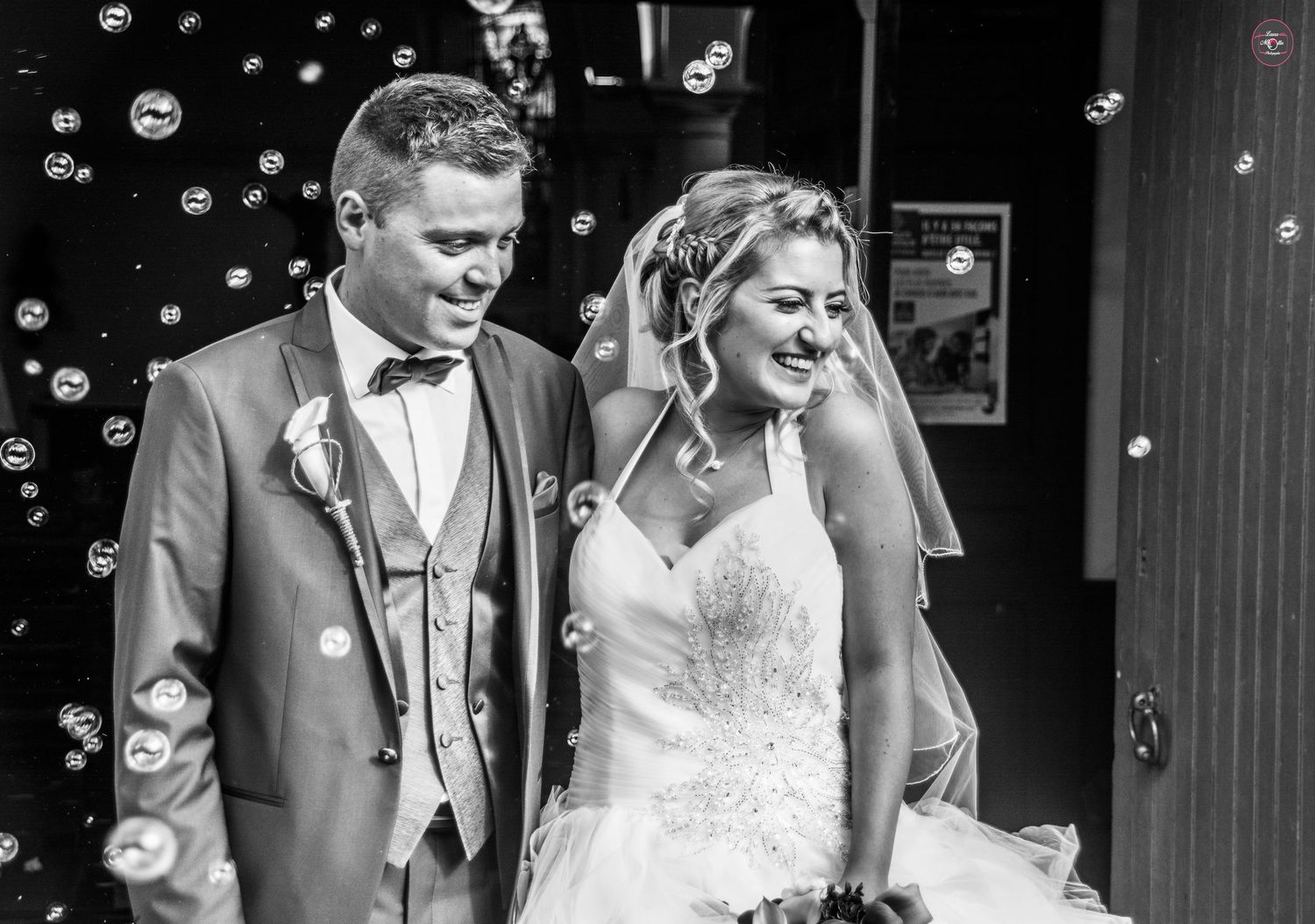 Wedding couple surrounded by floating bubbles in dramatic black and white.
