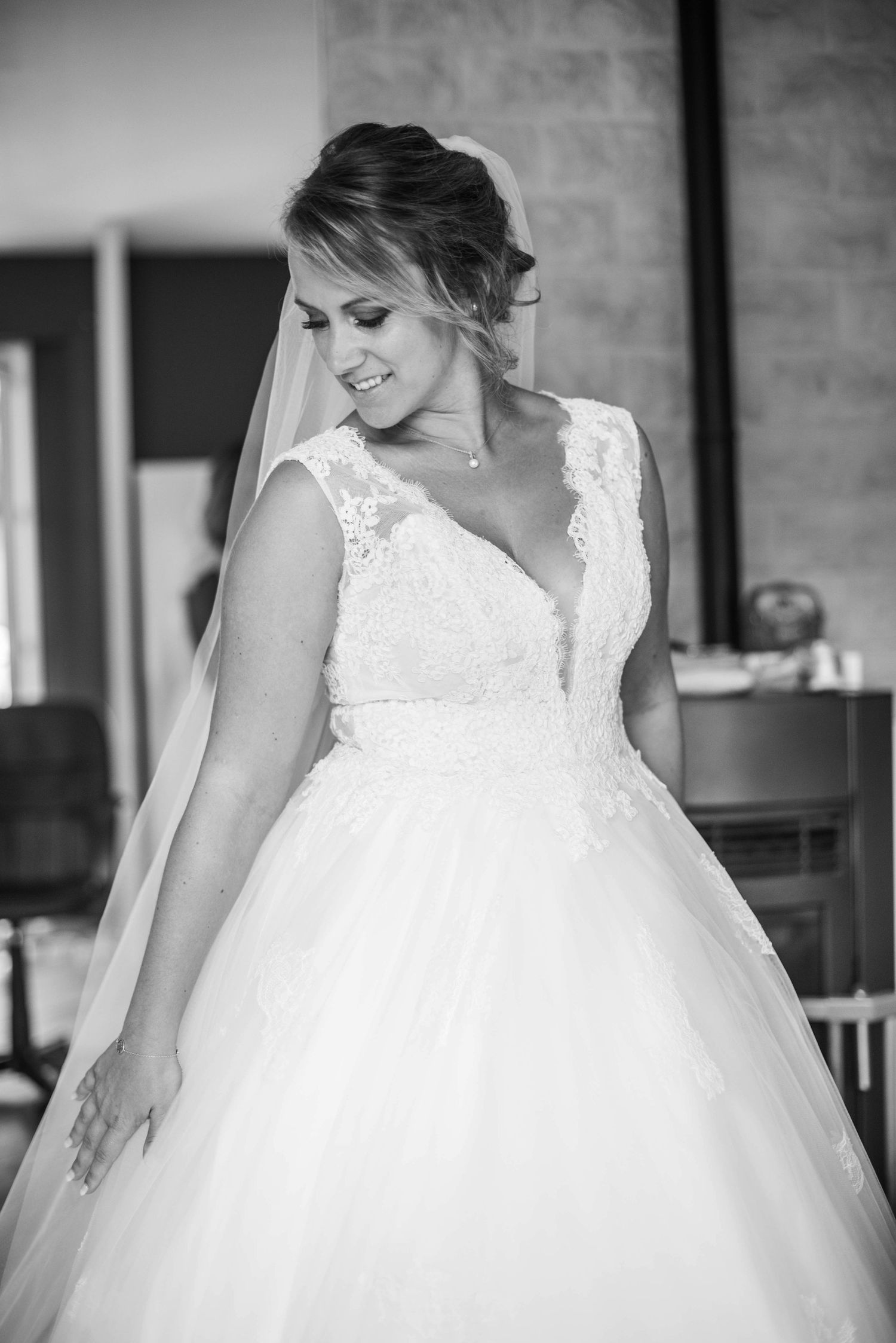 Close-up details of a white lace wedding dress with delicate embellishments.