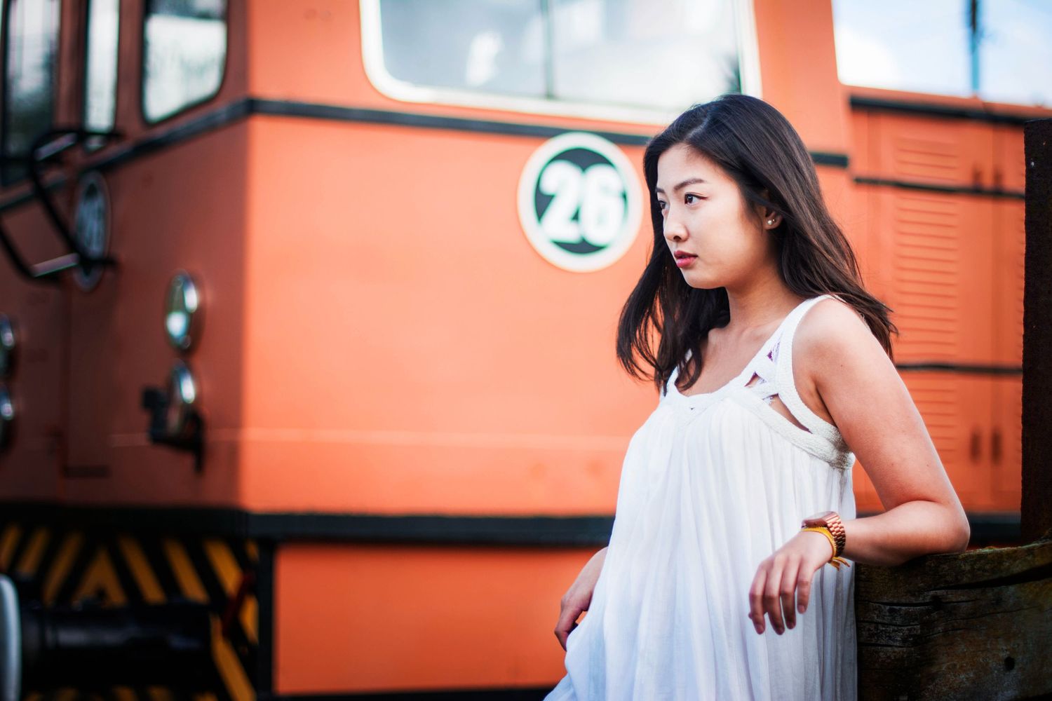 Casual portrait against orange industrial background.
