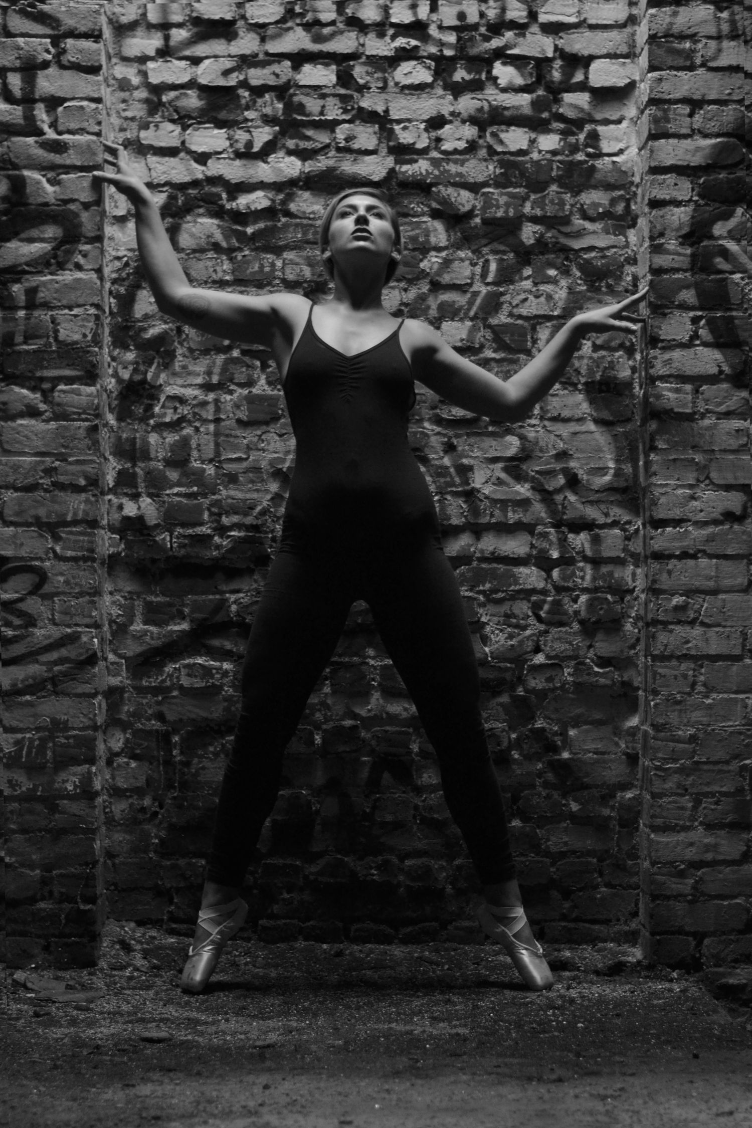 Black and white sequence showing dramatic poses against textured brick wall.