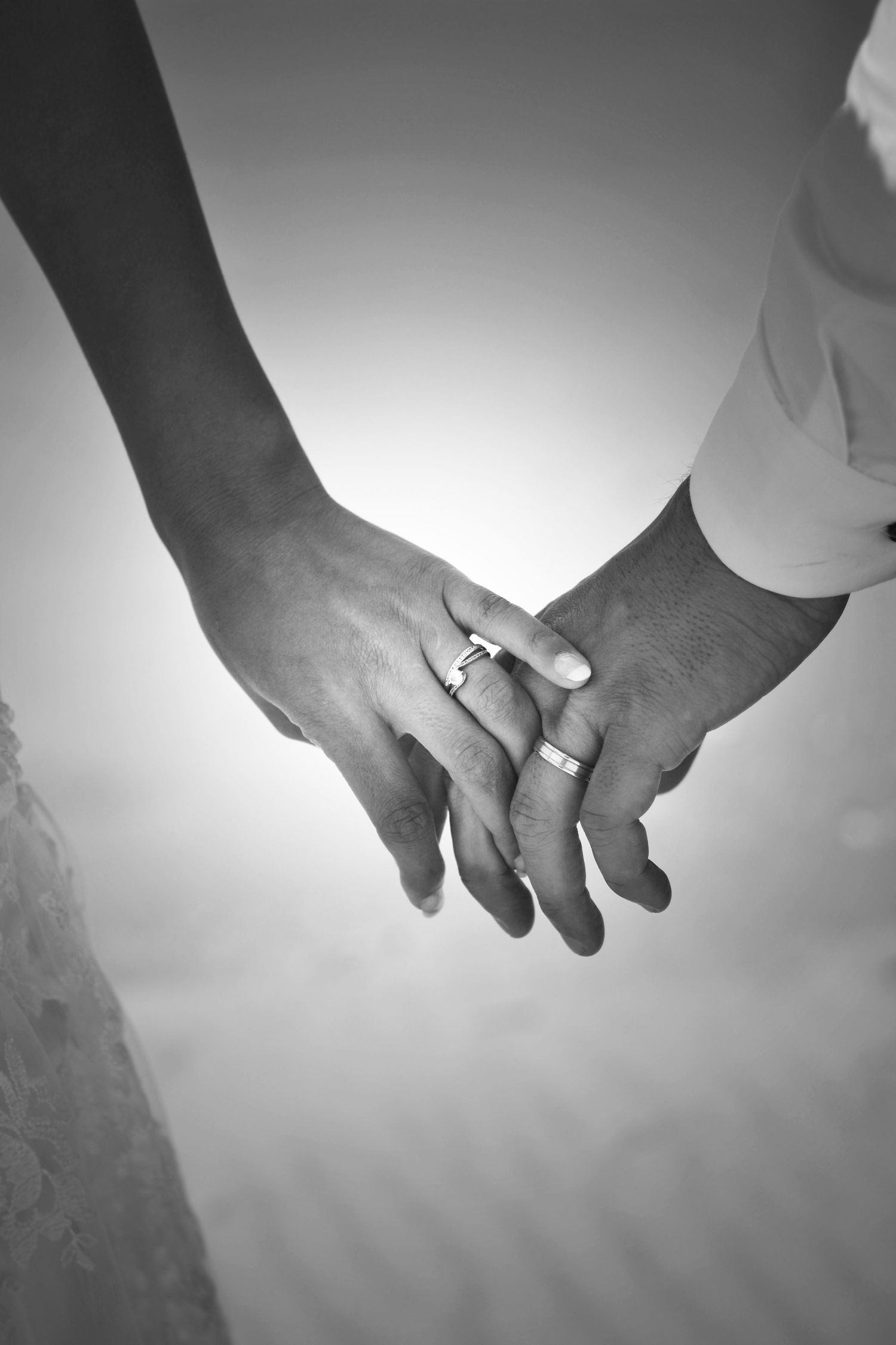 Series of black and white photos showing newlyweds holding hands with wedding rings.