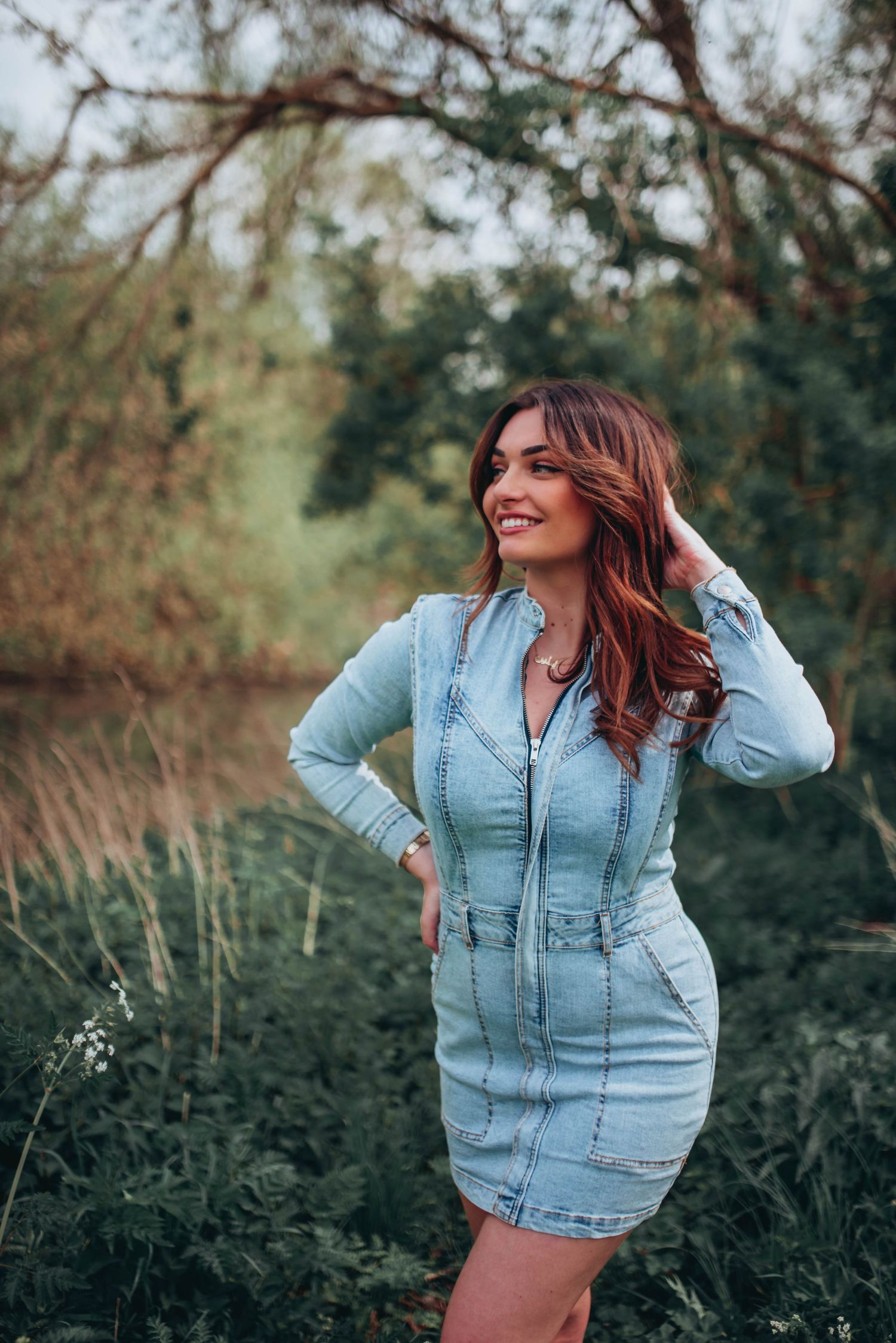 Casual outdoor photoshoot in a natural setting featuring light denim fashion.
