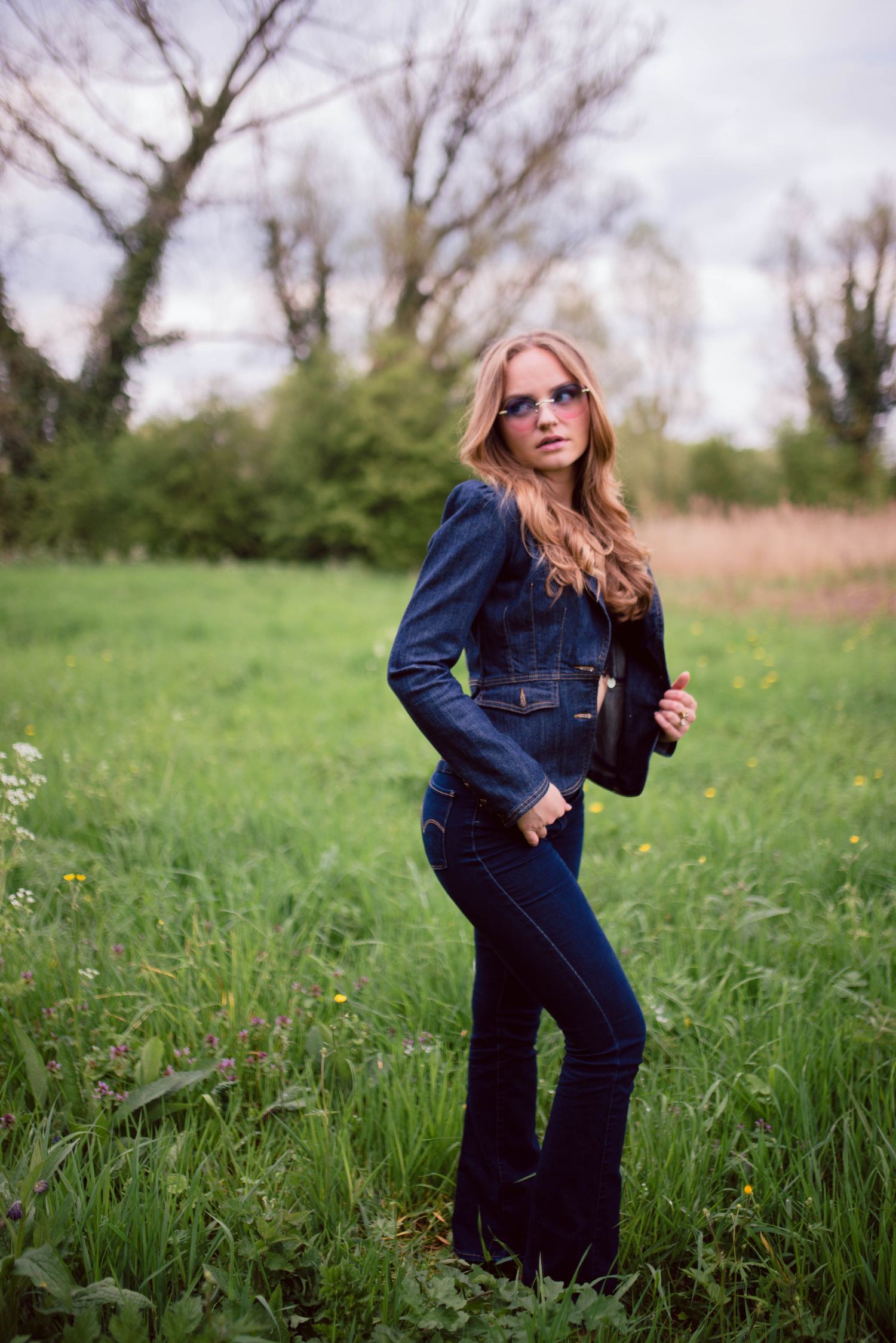 Spring meadow photoshoot with green grass and natural lighting.