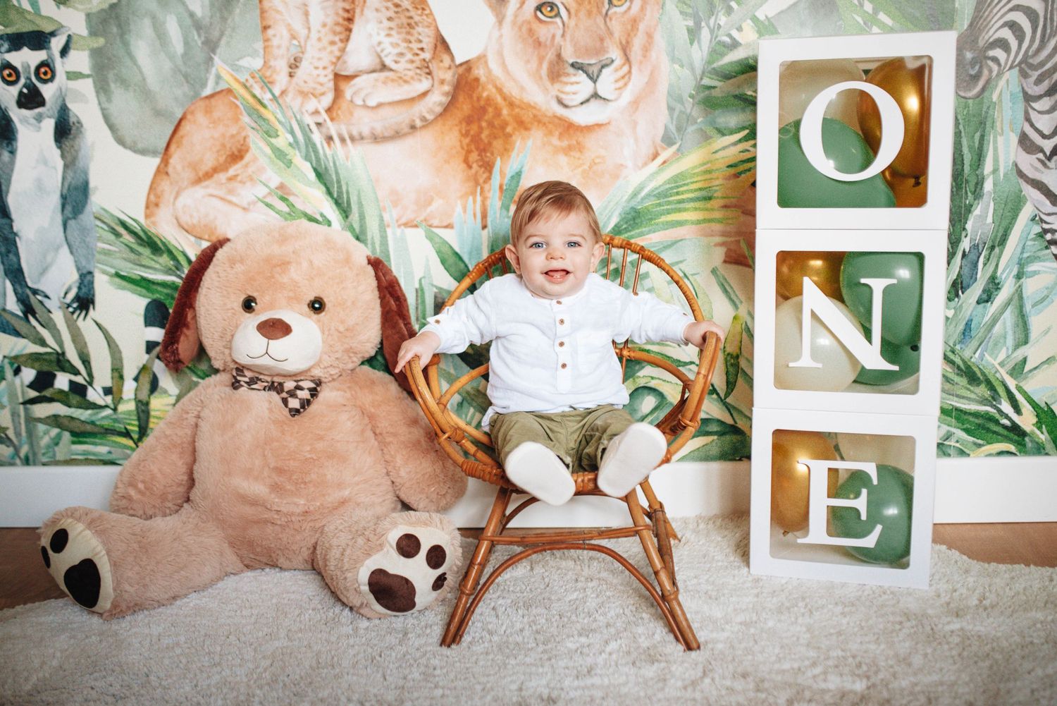 Safari themed nursery photoshoot with stuffed animals and decorative elements.