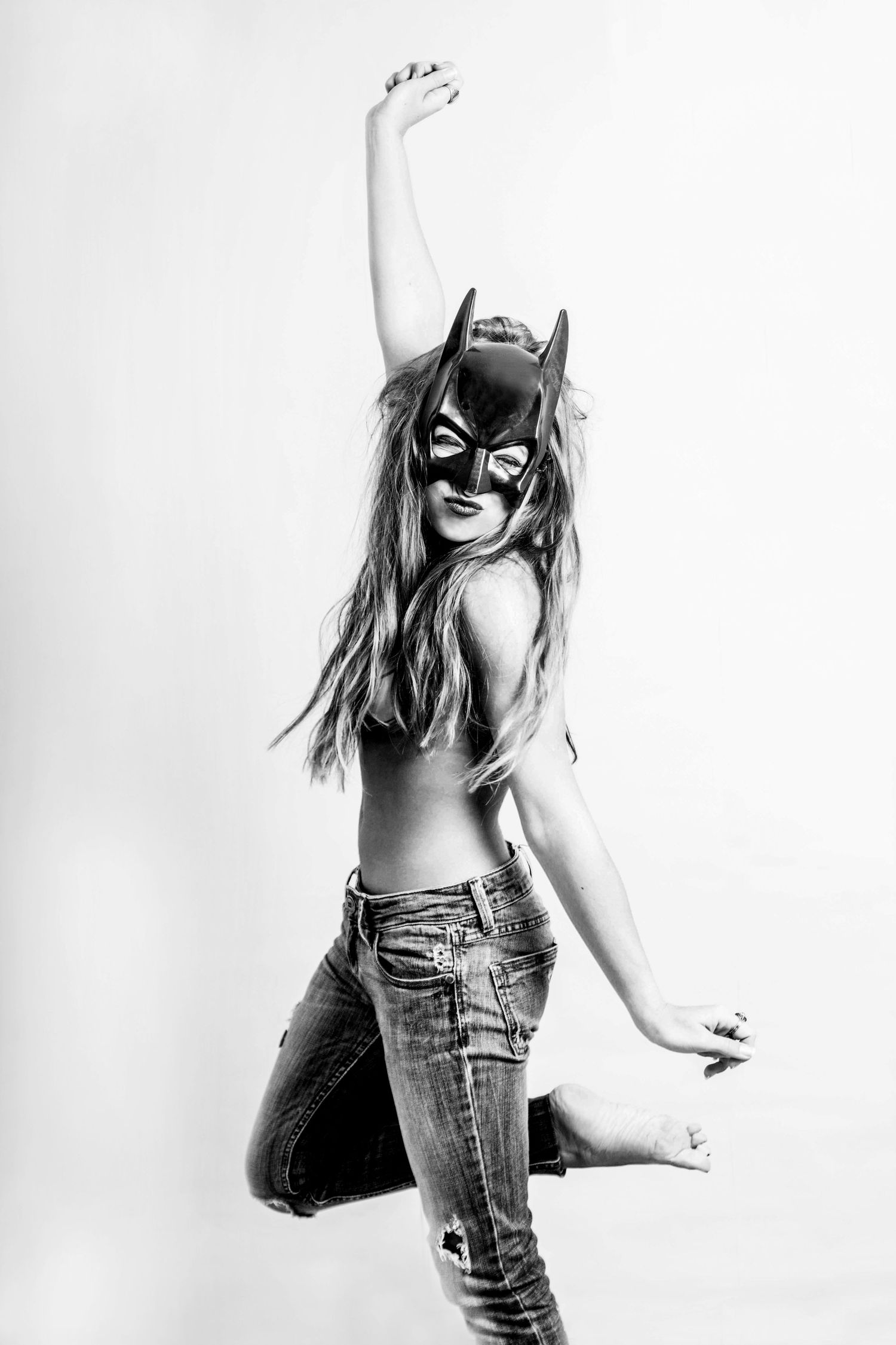 Black and white studio shots featuring superhero mask and casual denim styling.