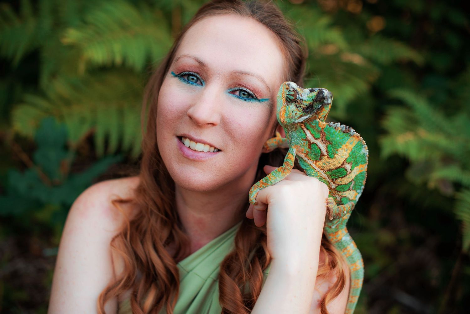 Whimsical forest portrait with a chameleon perched delicately on hand.