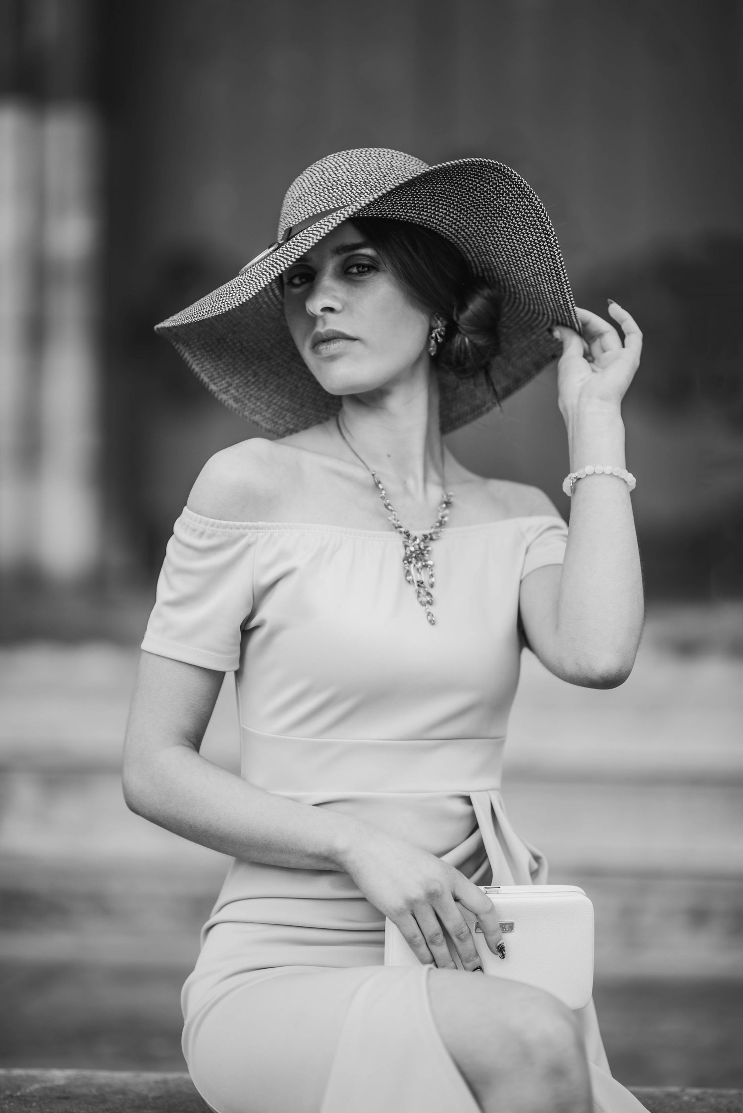Elegant black and white portrait featuring a wide-brimmed hat and classic vintage styling.