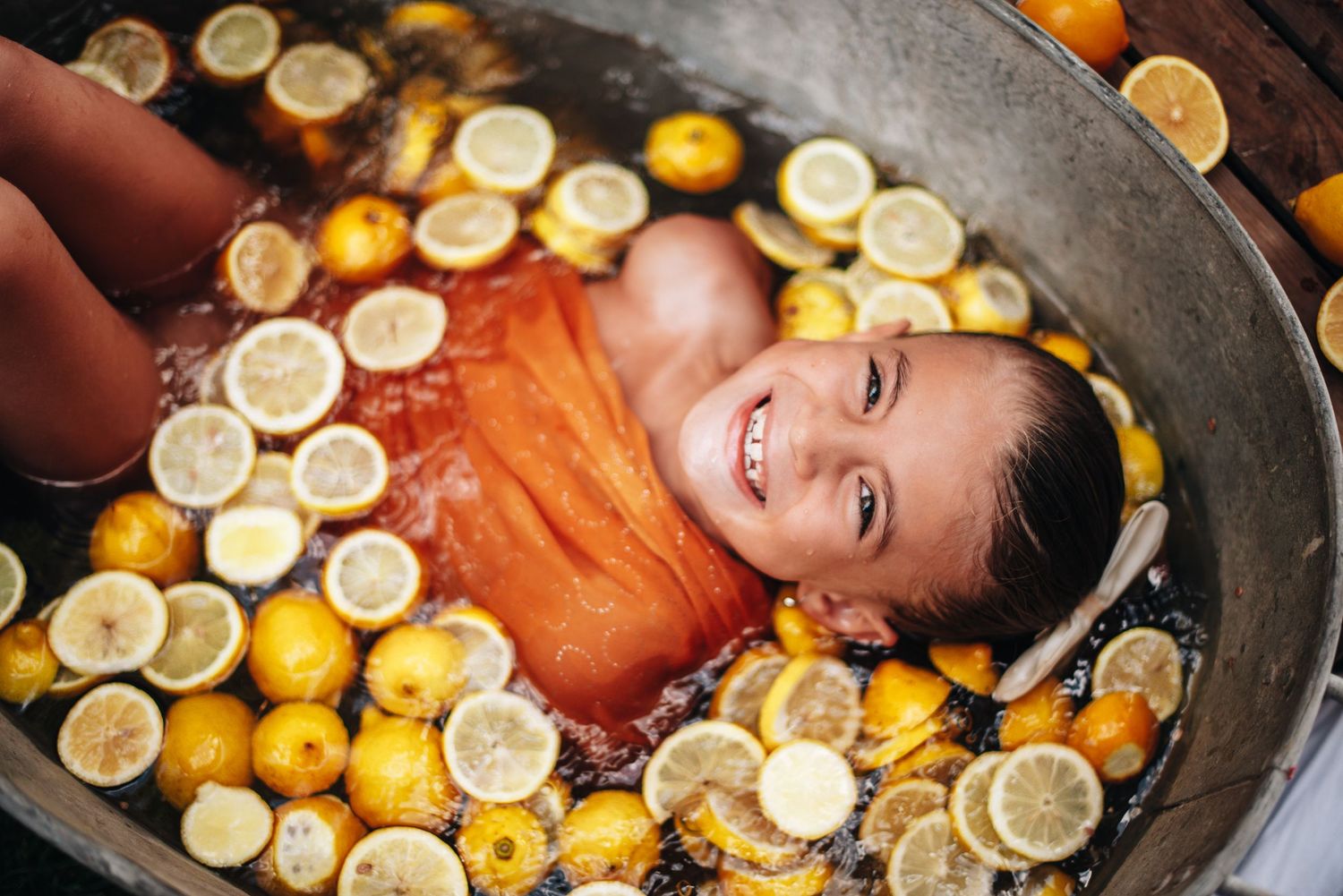 Artistic citrus bath photography with bright yellow lemons creating a cheerful scene.