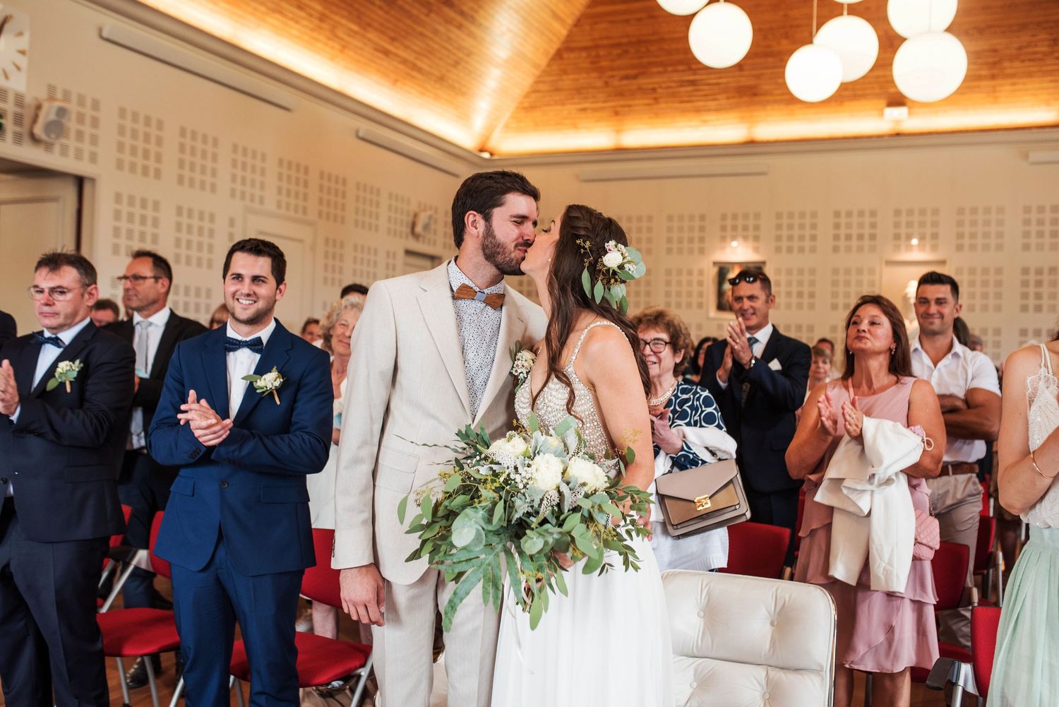 Wedding reception in elegant venue with warm lighting and greenery decorations.