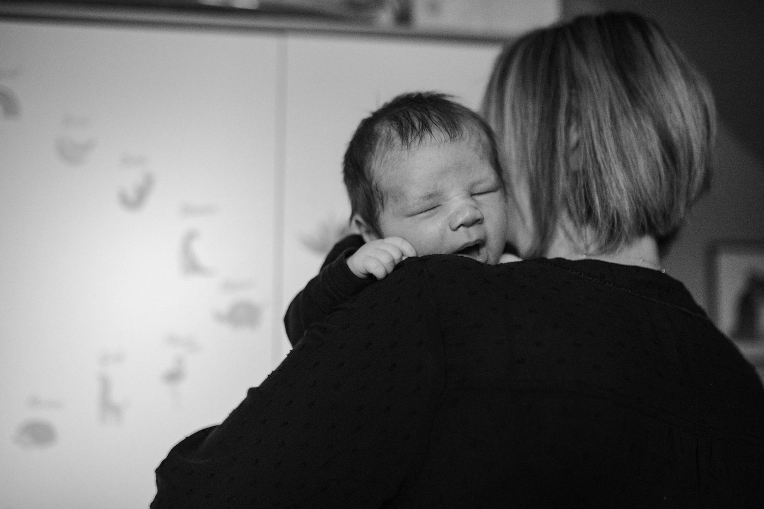 Black and white image showing a tender moment in a nursery setting.