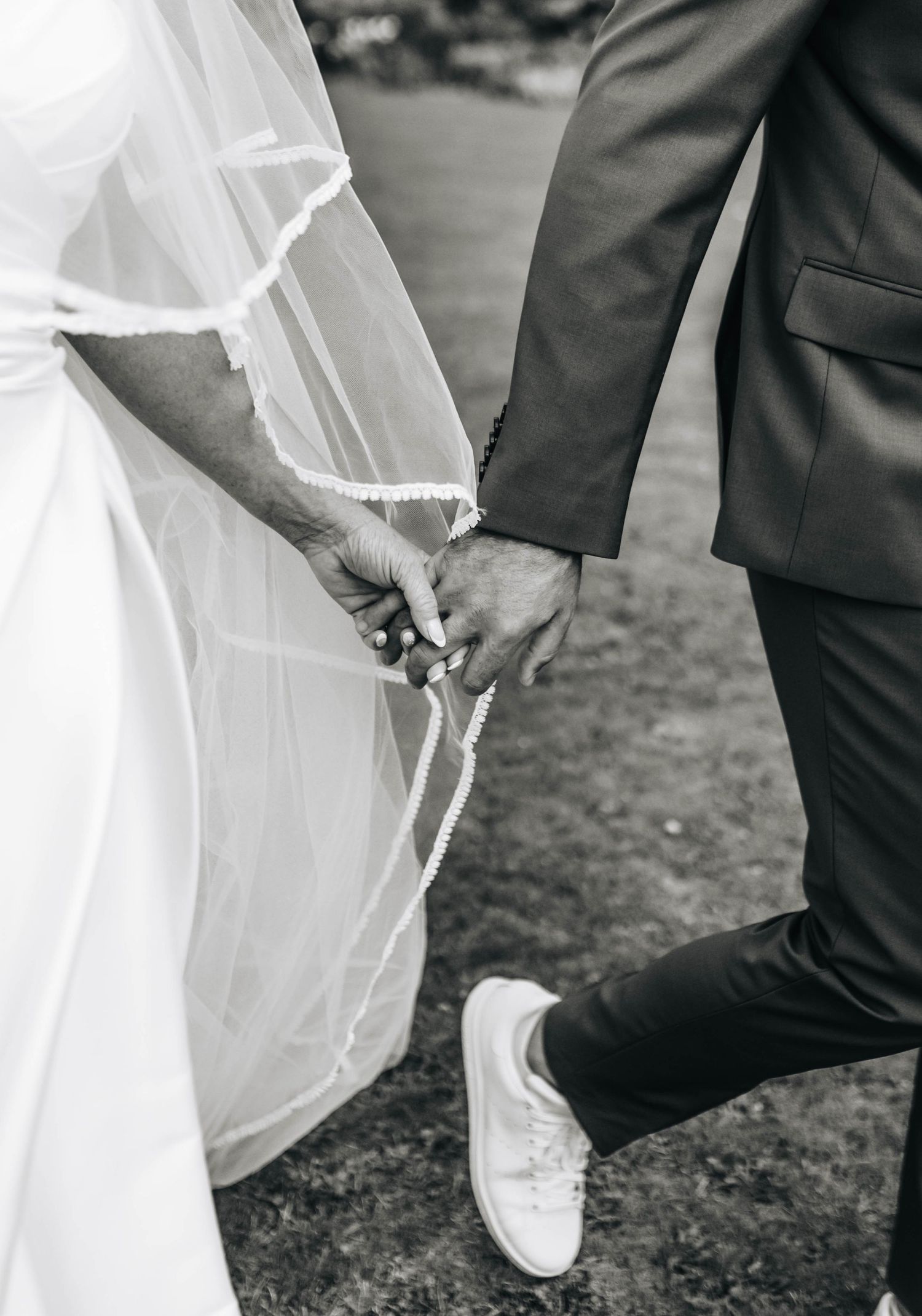Close-up shots of wedding dress details and formal shoes on grassy ground.
