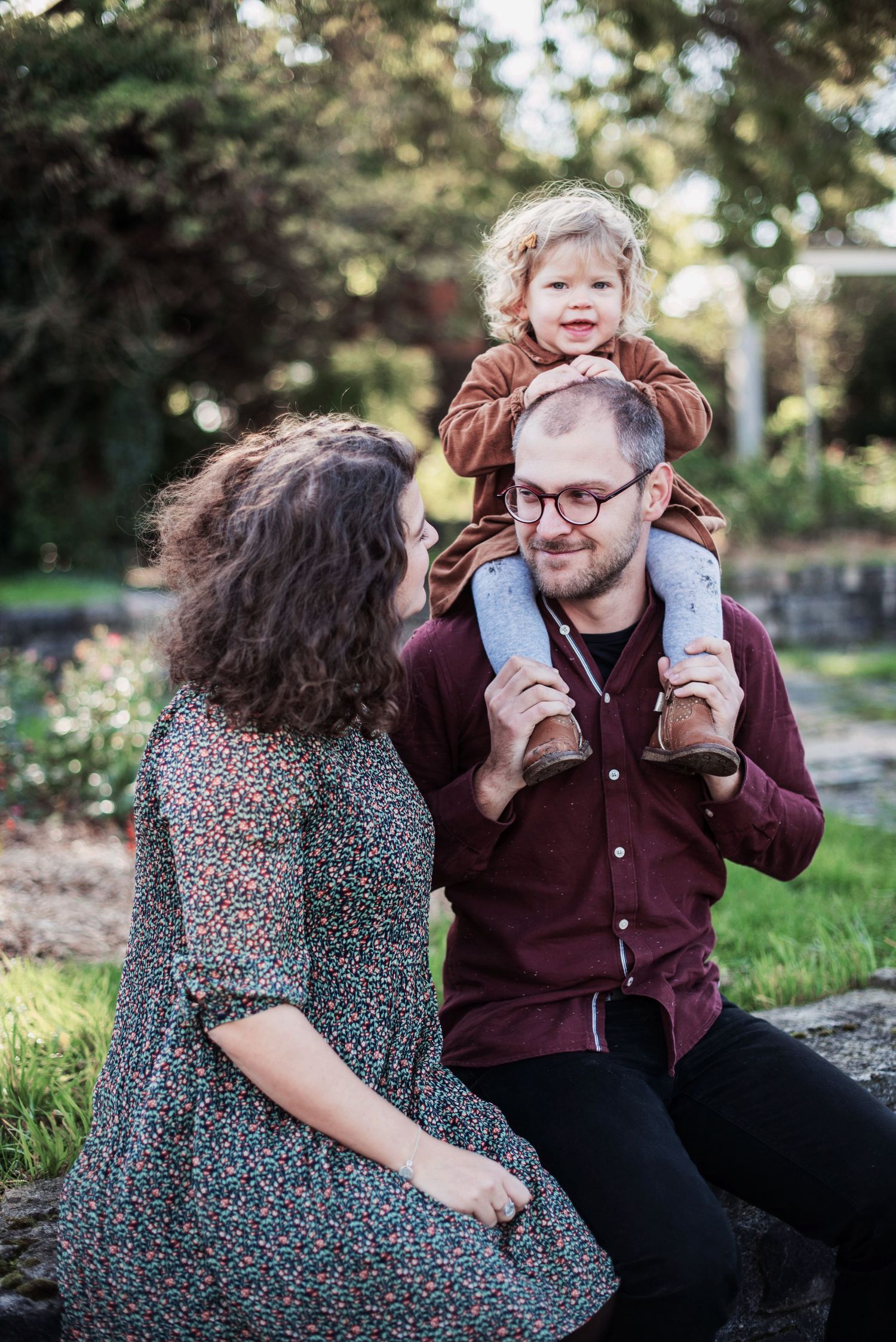 Family enjoying a playful moment together outdoors on a sunny autumn day.