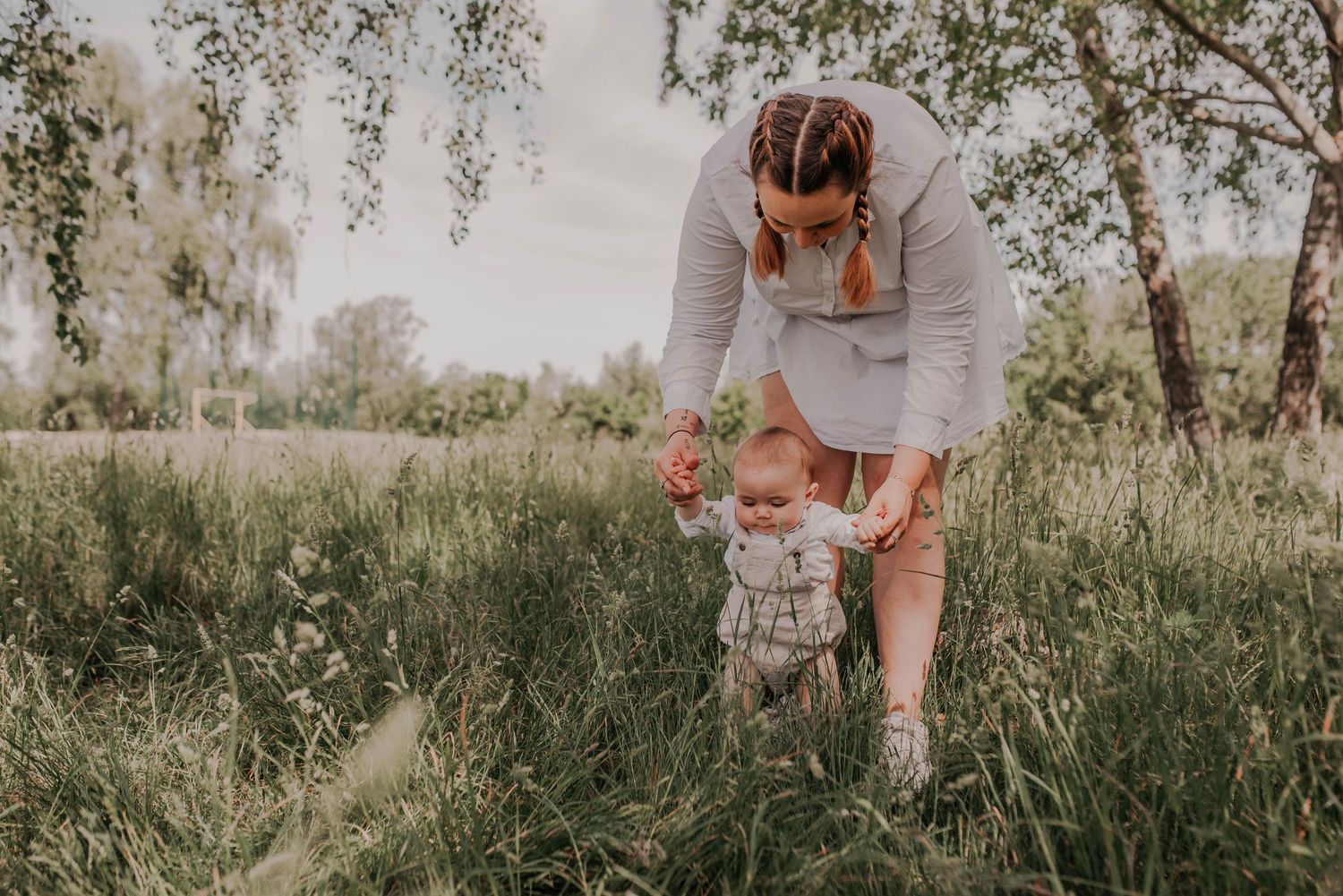 A tender family moment captured in a meadow with natural lighting.