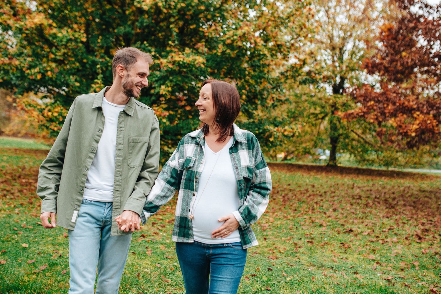 Casual outdoor maternity photos with couples in denim and neutral tones.