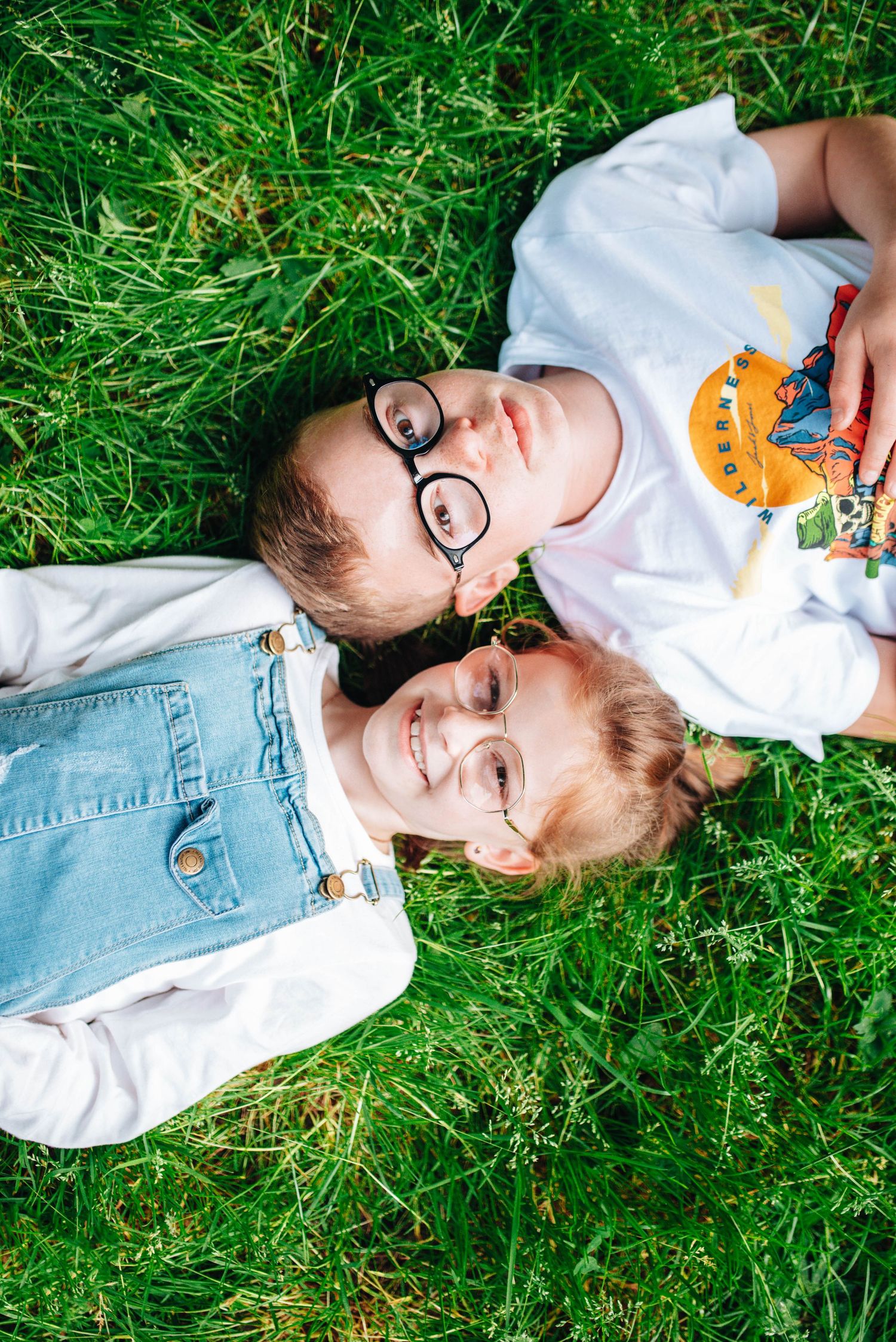 Candid photos of people lying in green grass wearing casual clothes and graphic t-shirts.