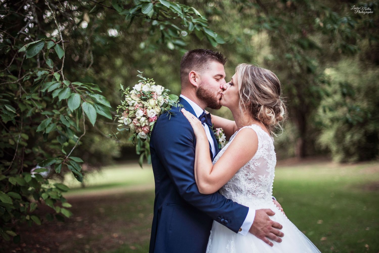 Romantic outdoor wedding portrait among green foliage and natural scenery.