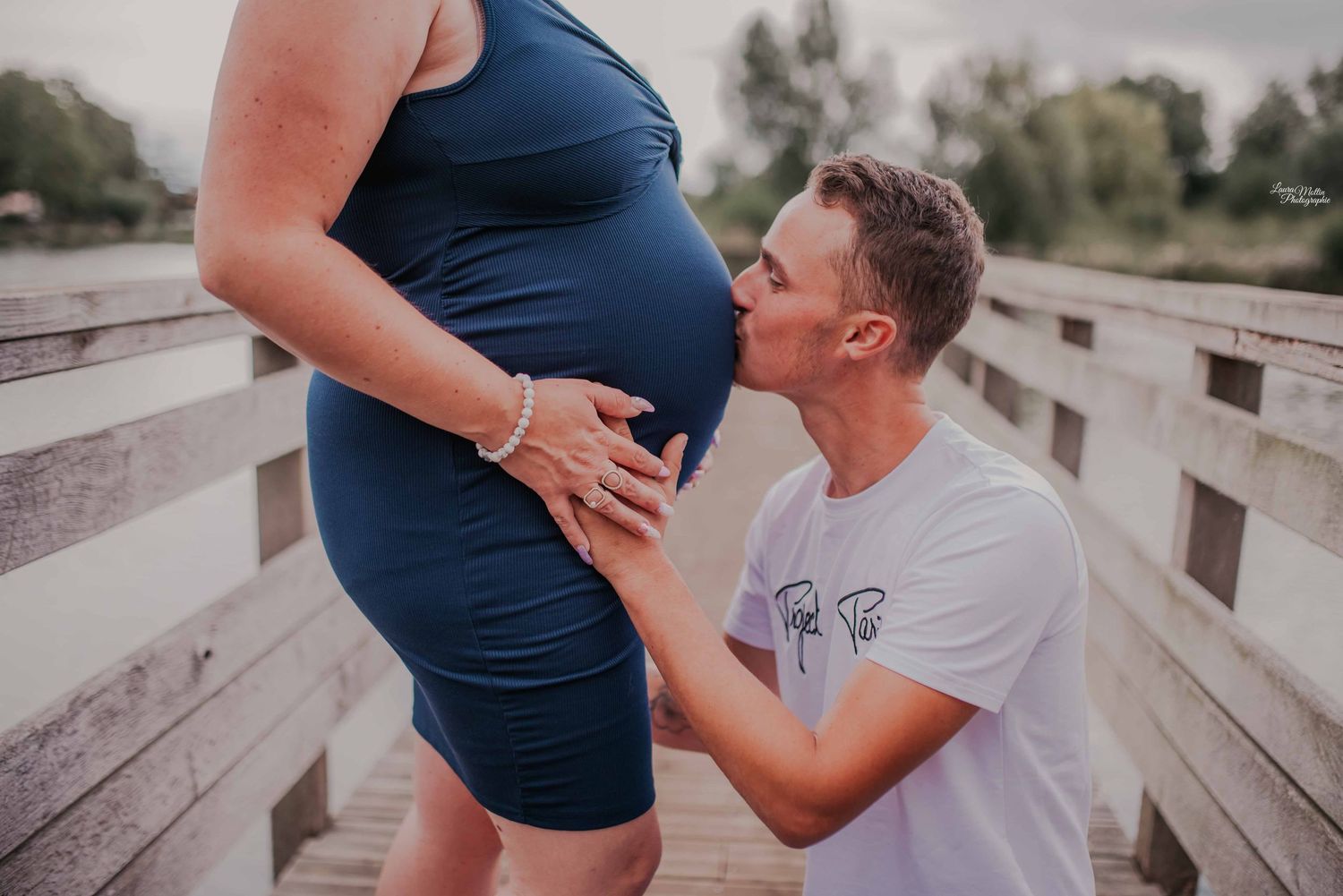 Maternity photo session on wooden bridge with navy blue dress.