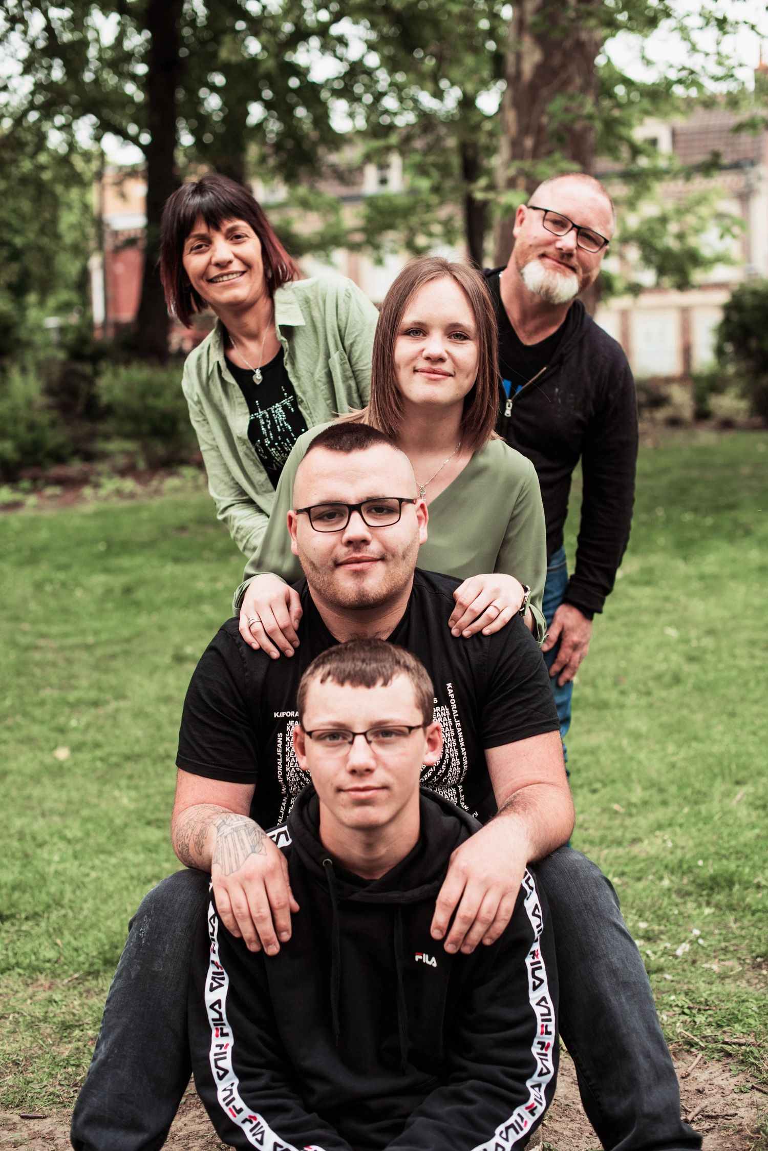 Group photo taken outdoors with natural greenery in background.