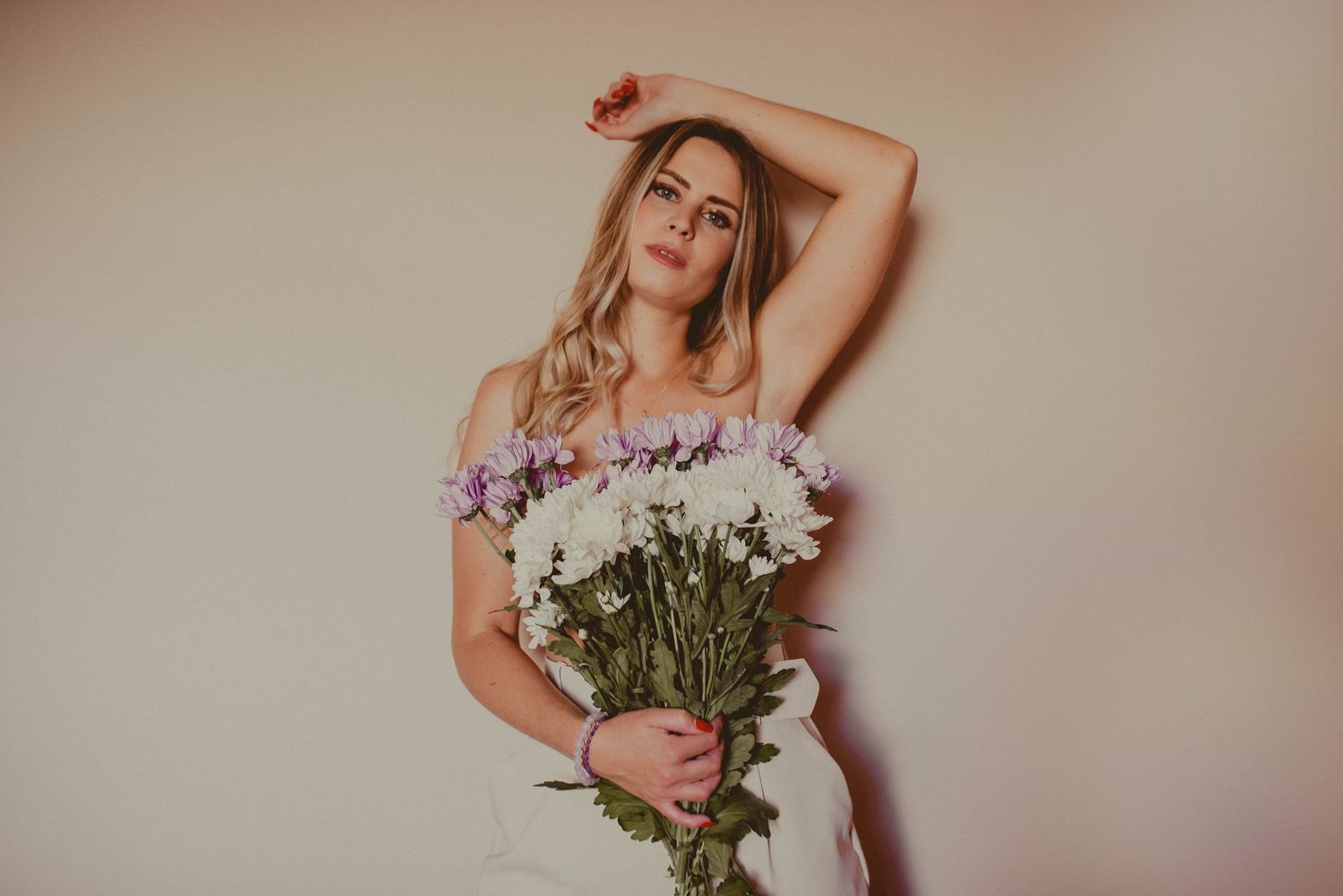 Artistic portrait series with flowers and soft neutral background.