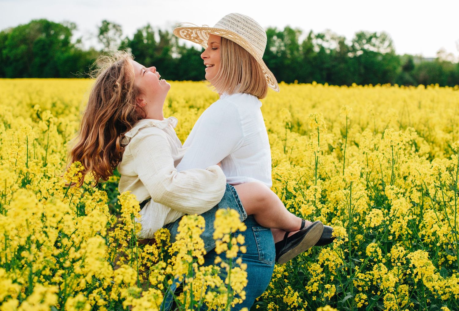 Family walking through blooming yellow canola field on sunny day.