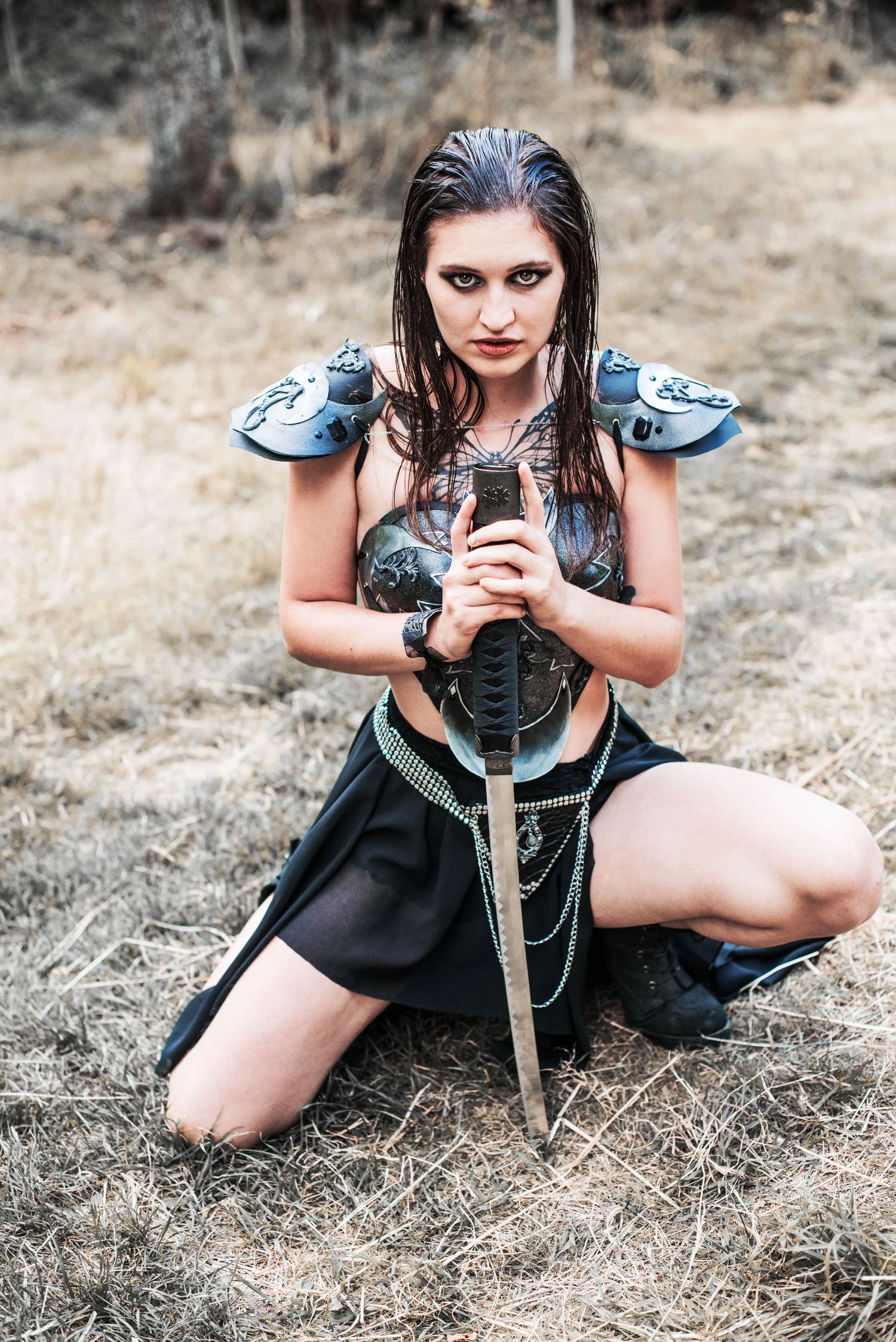 A fantasy warrior poses with a sword in medieval-inspired costume.